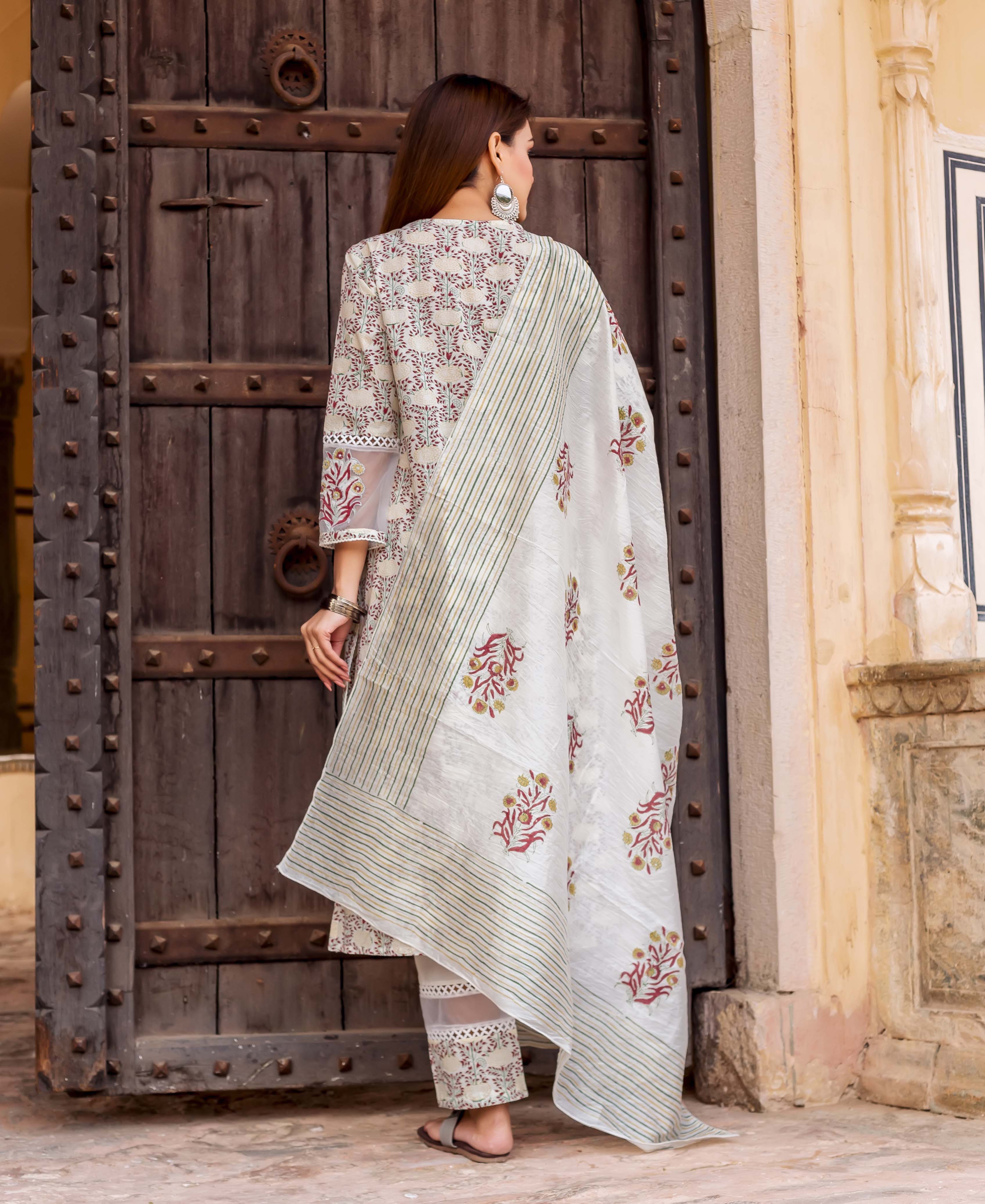 Model in an off-white block printed kurta set with red-yellow floral motifs and striped dupatta.