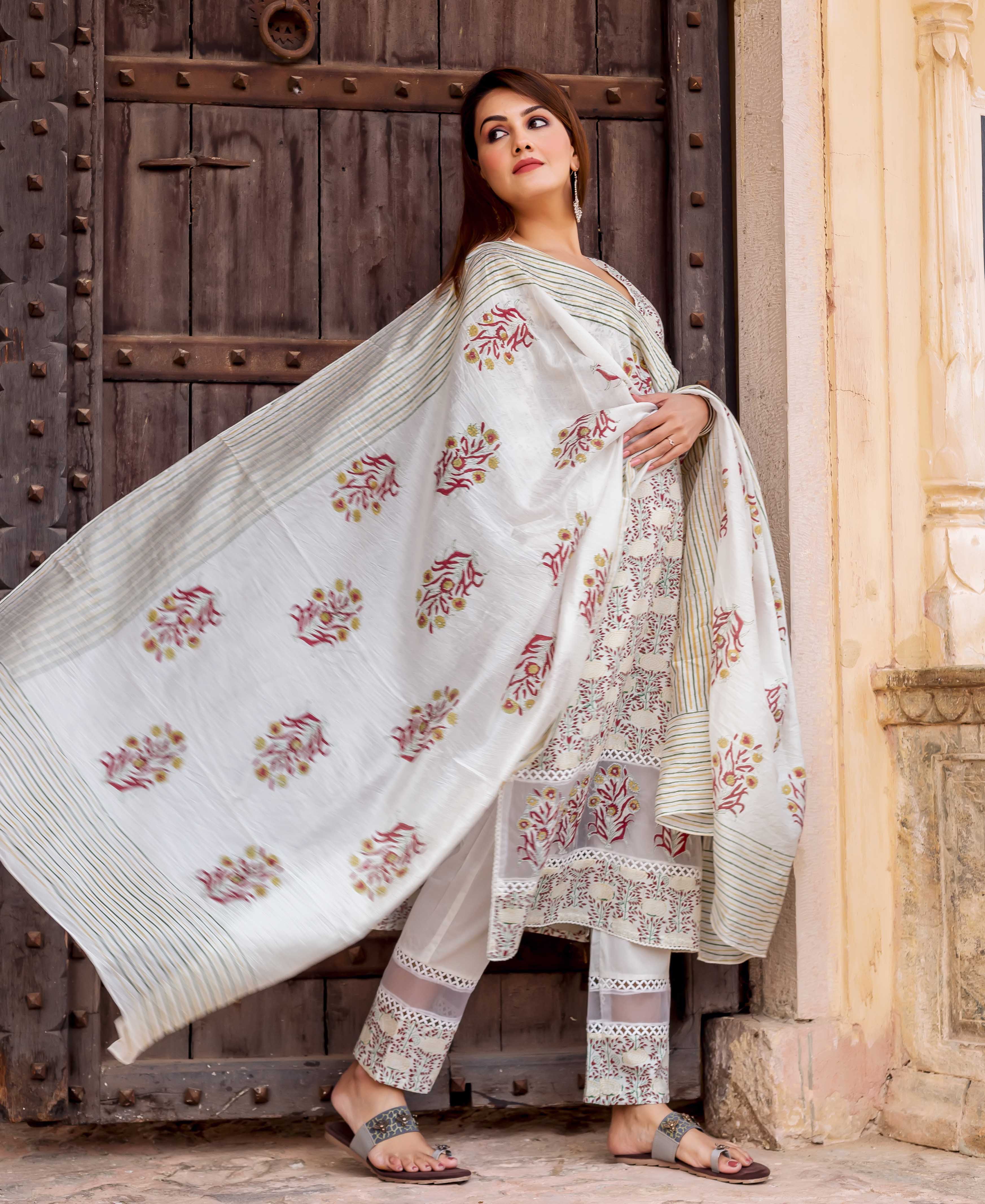 Model in off-white block-printed kurta set with red and yellow floral patterns, striped dupatta.