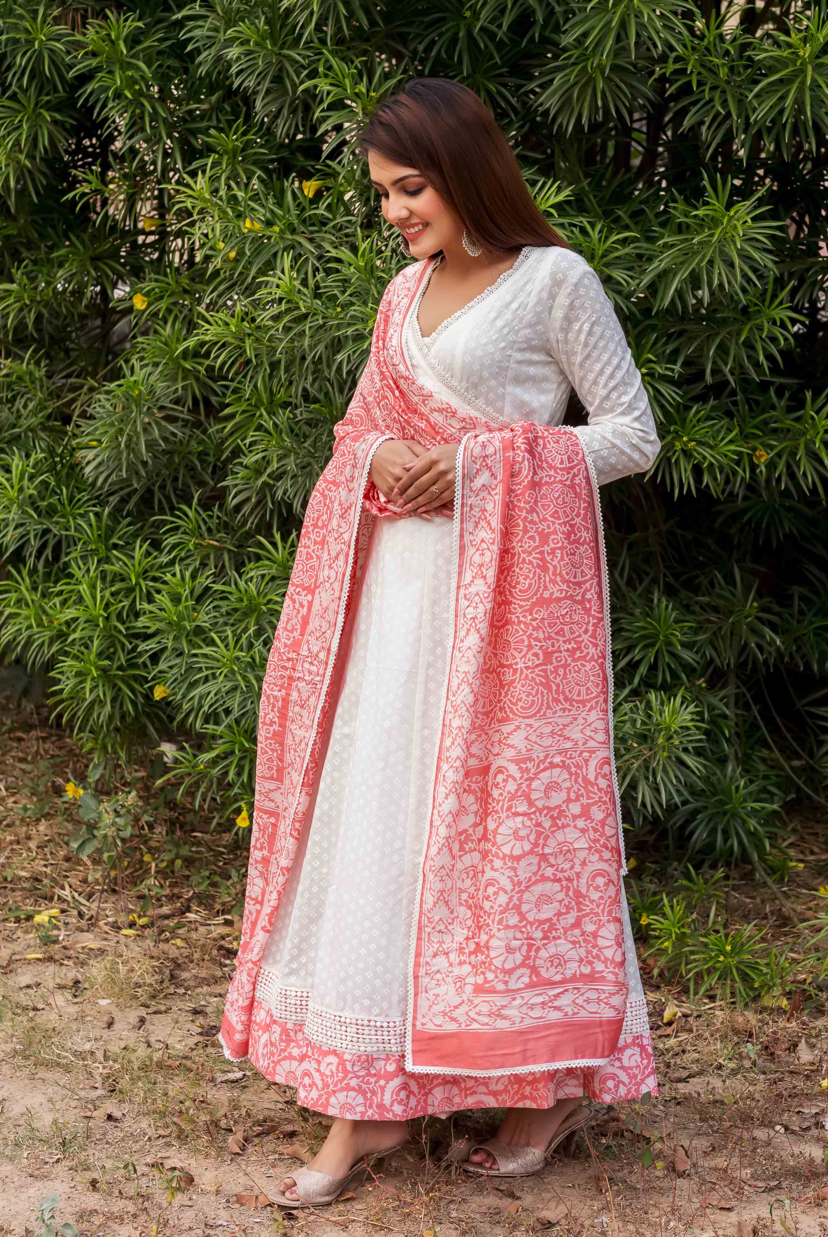 Front view of model wearing a white Angrakha dress with a peach hand-block printed ethnic dupatta.