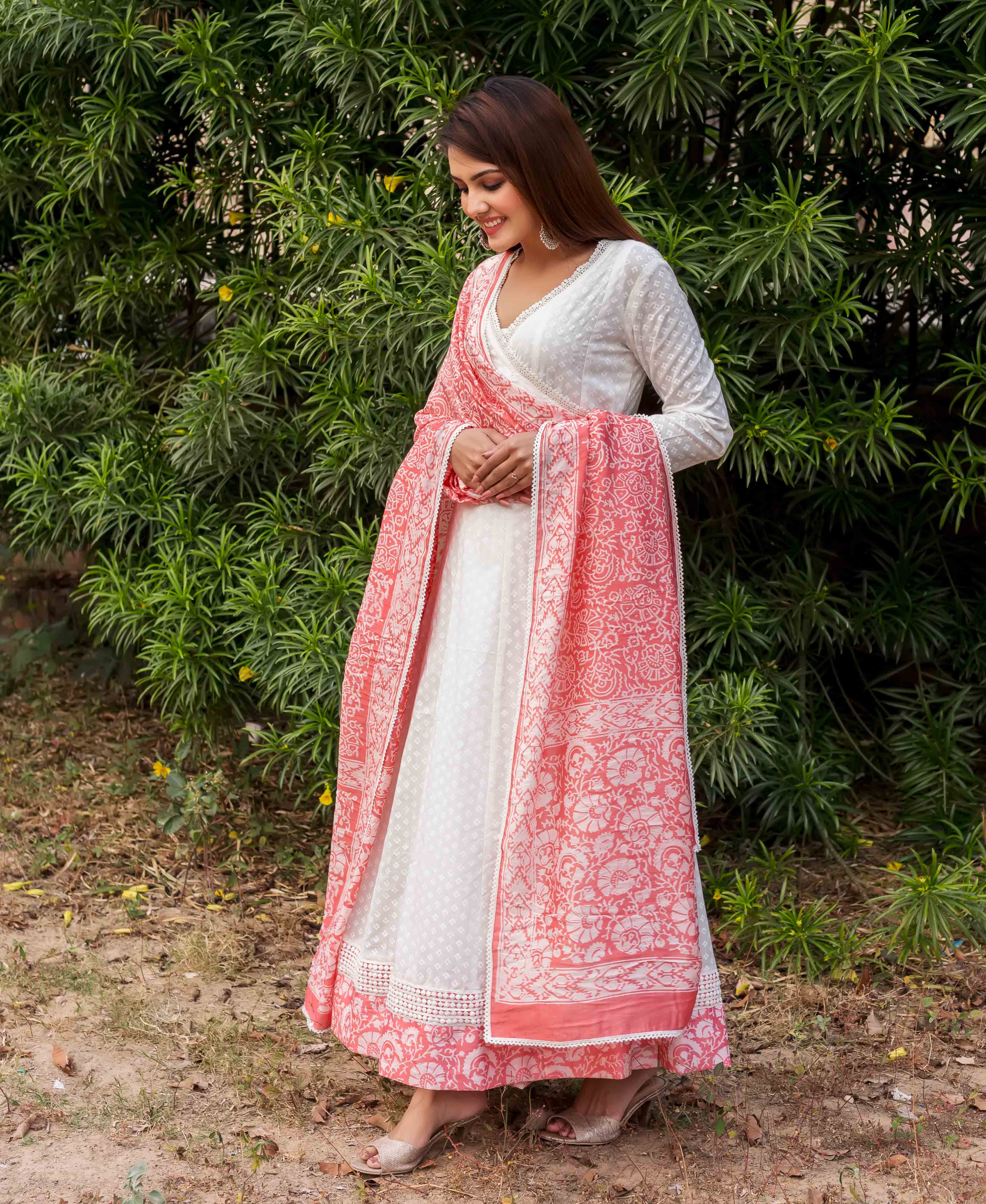 Front view of model wearing a white Angrakha dress with a peach hand-block printed ethnic dupatta.