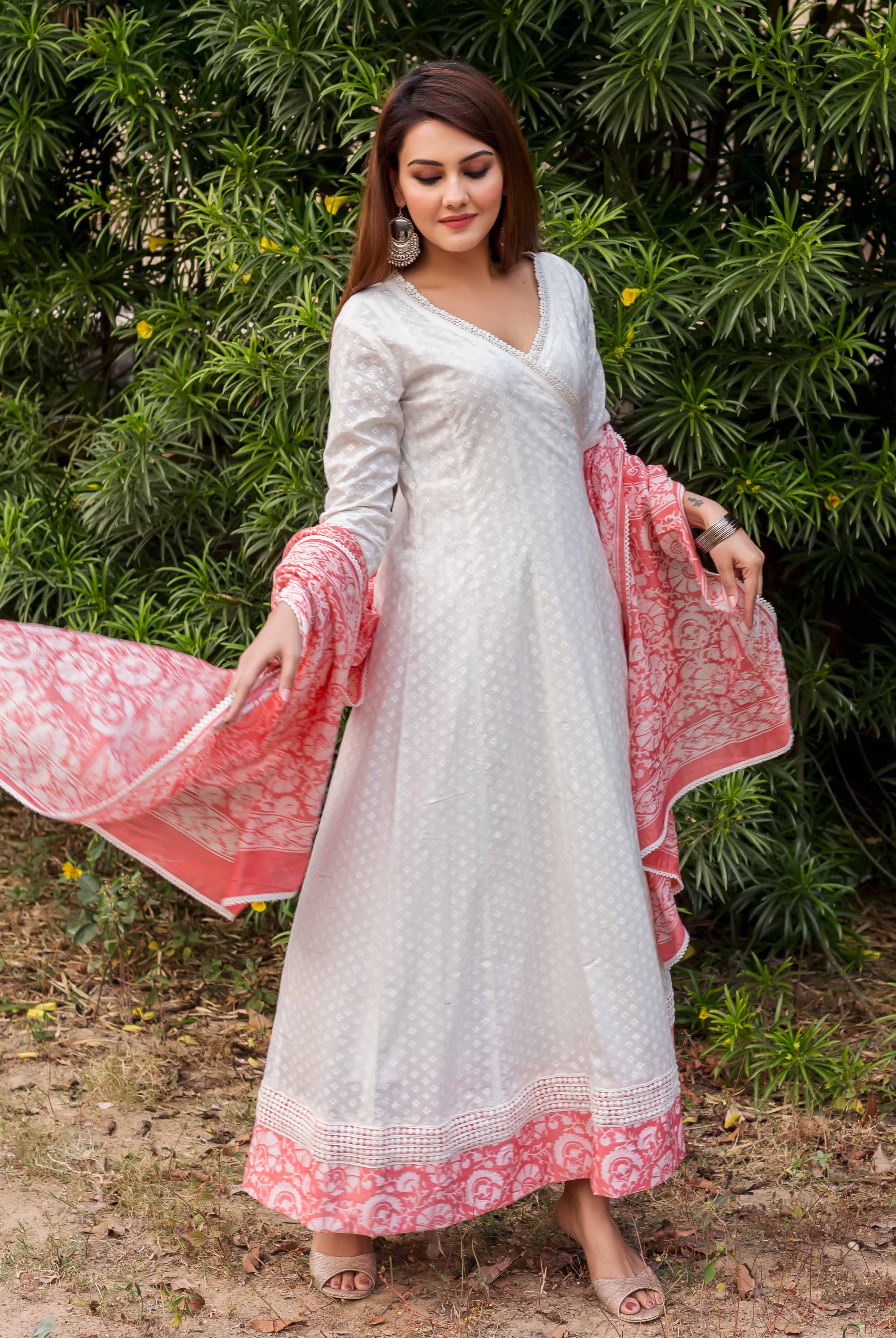 Model wearing white Angrakha dress with subtle pattern, peach hand-block printed border and dupatta.