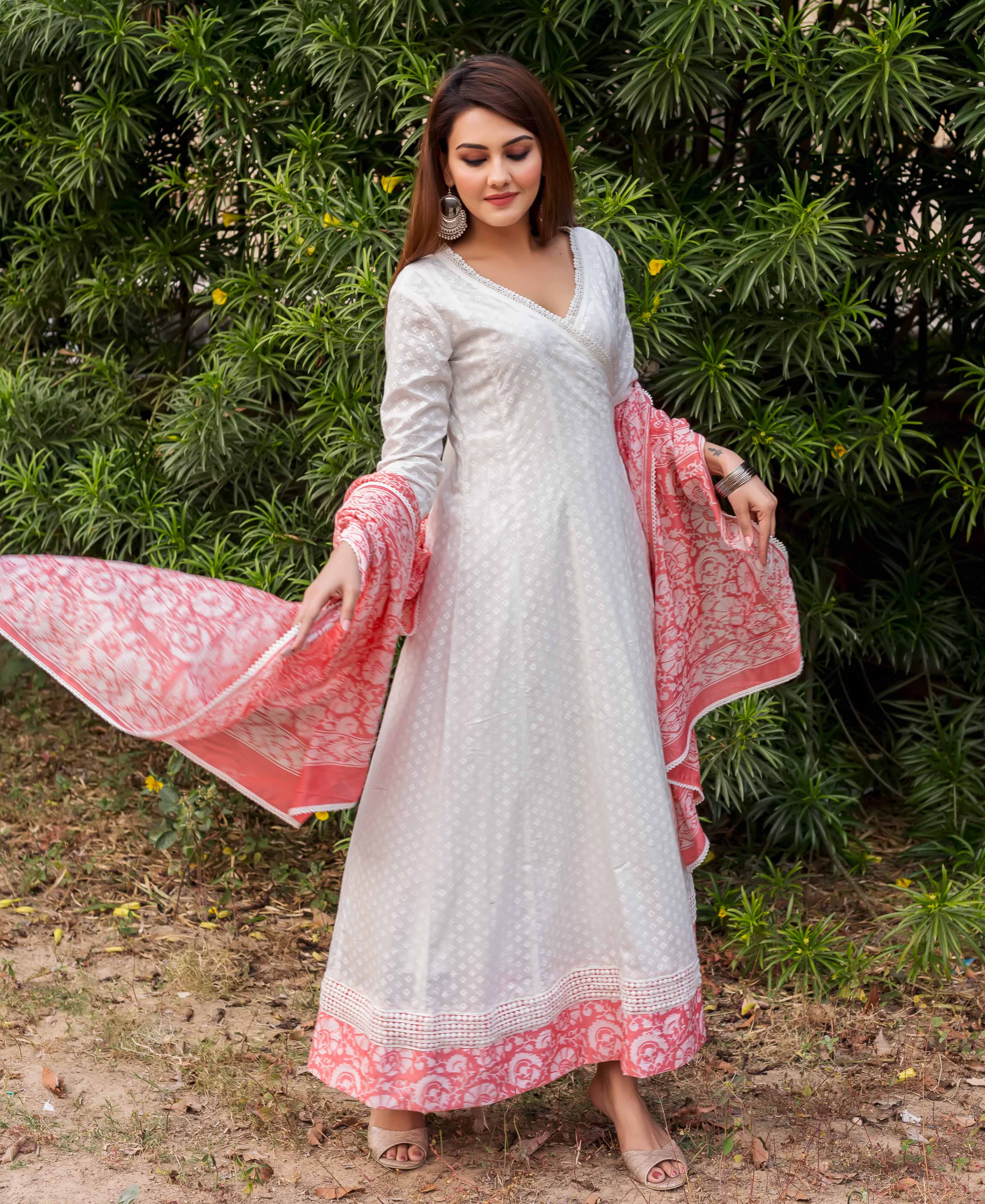 Model wearing white Angrakha dress with subtle pattern, peach hand-block printed border and dupatta.