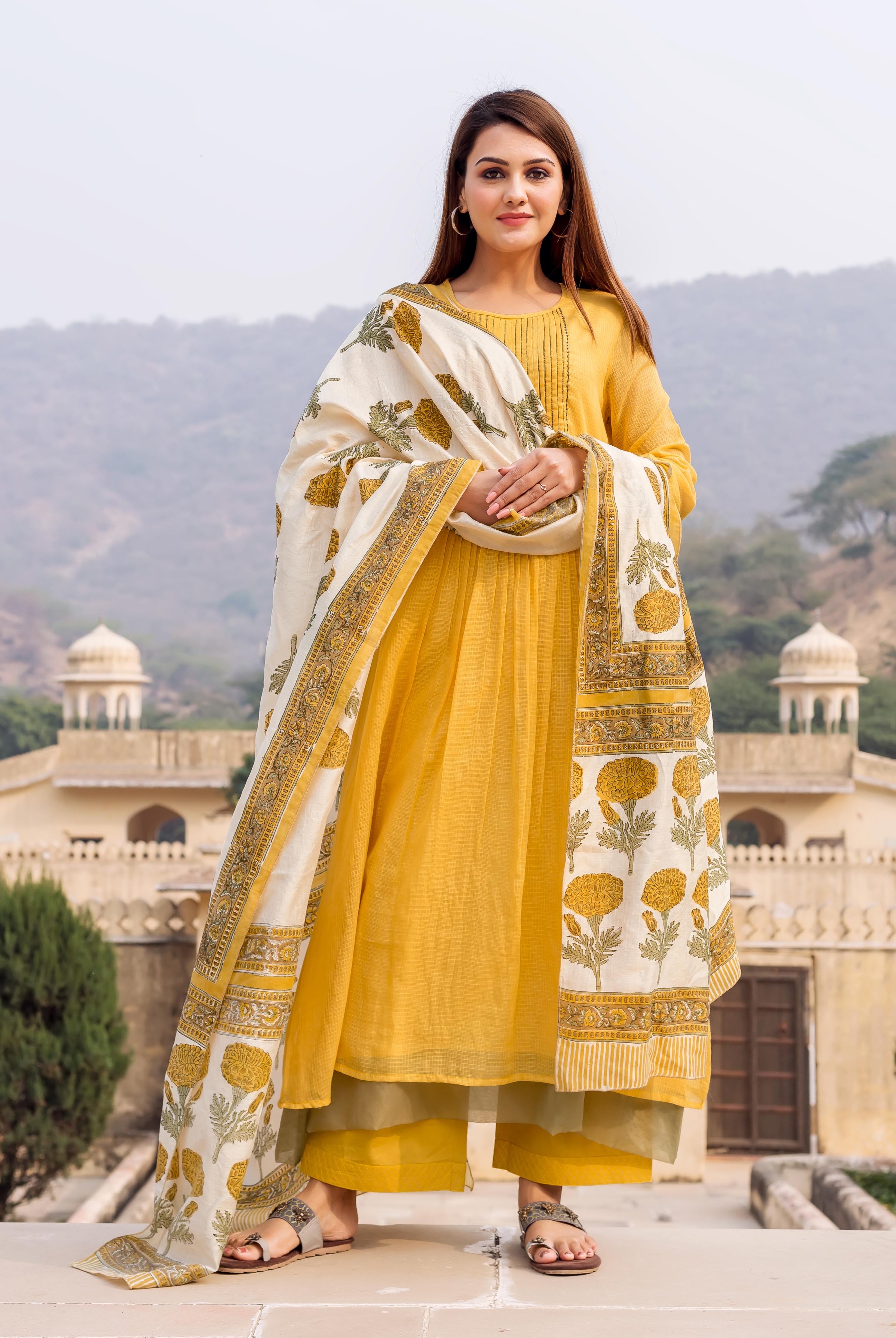 Model wearing honey yellow embroidered kurta, olive palazzo, and cream floral block print dupatta.