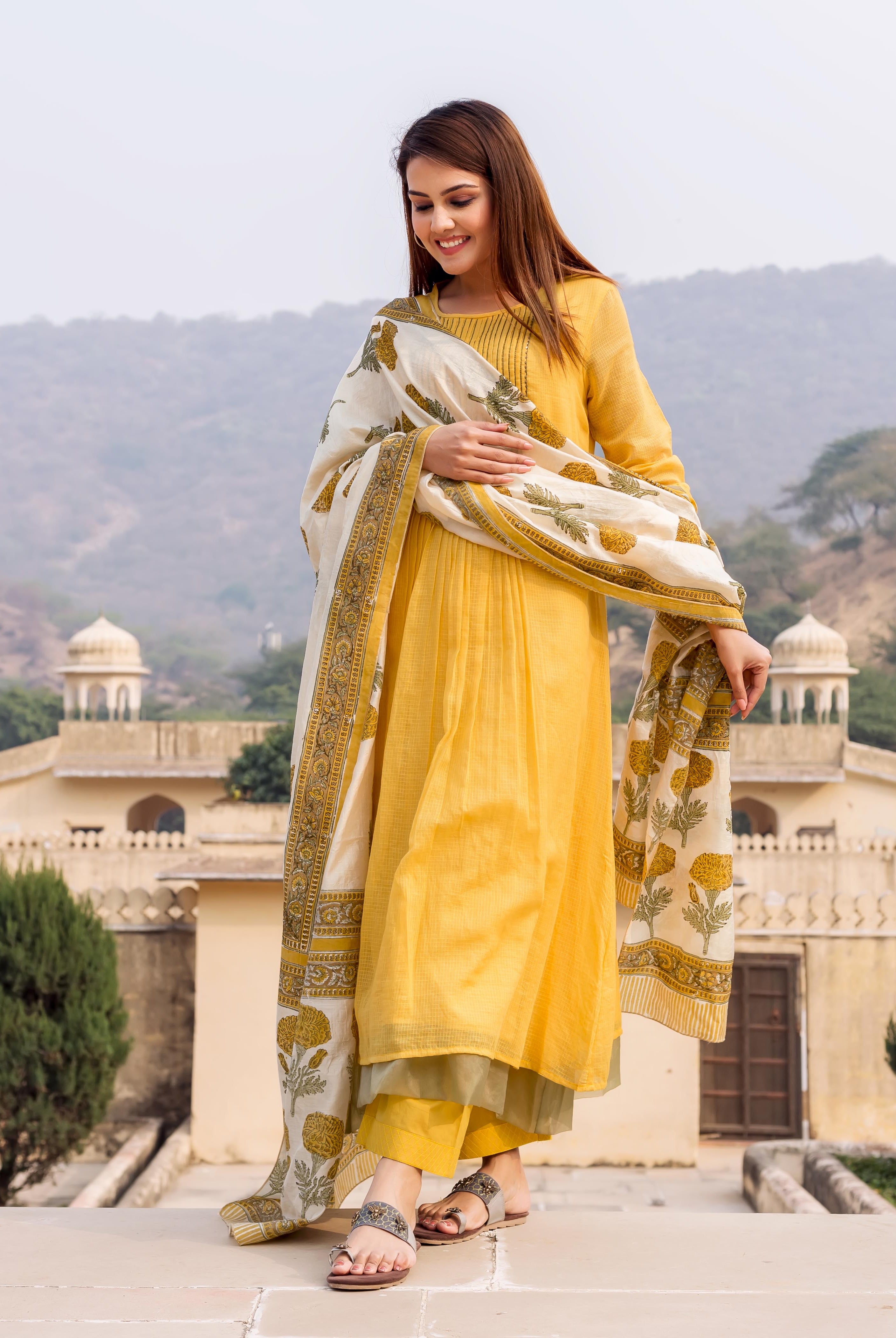 Model in honey yellow embroidered kurta, olive pants, and white hand-block-printed ethnic dupatta.