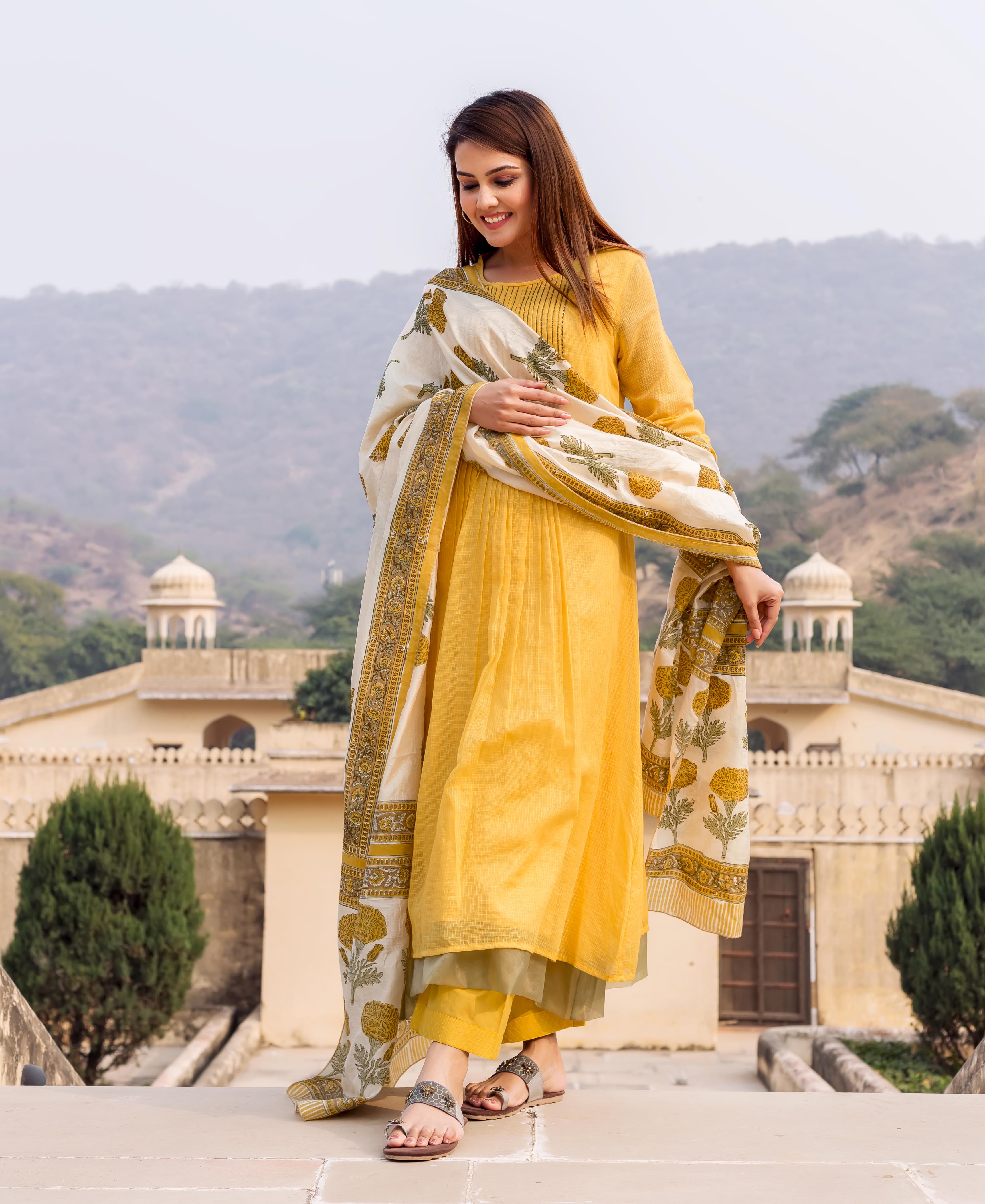 Model in honey yellow embroidered kurta, olive pants, and white hand-block-printed ethnic dupatta.