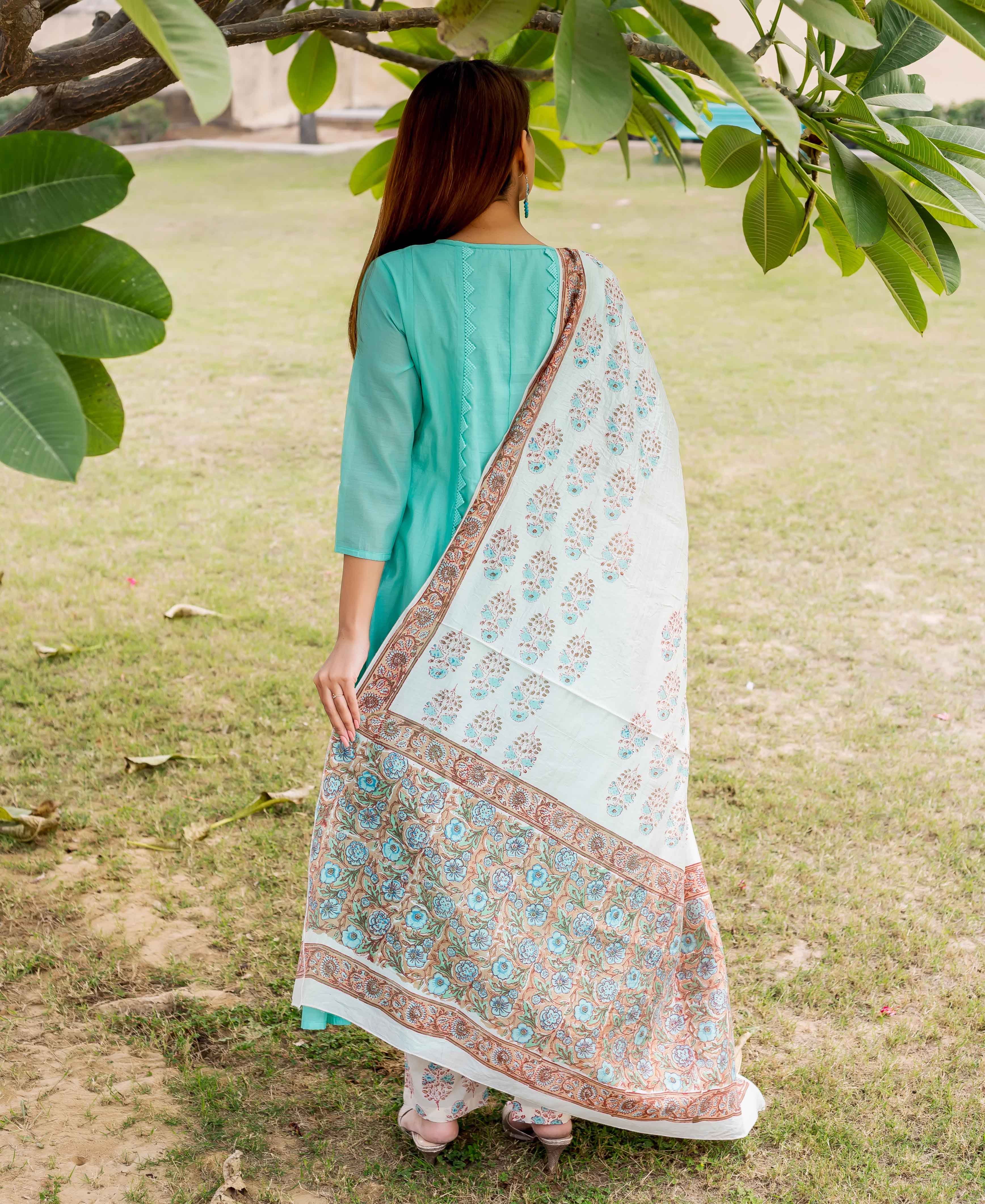 Back of woman in sea green embroidered kurta with block-printed floral dupatta and matching pants.