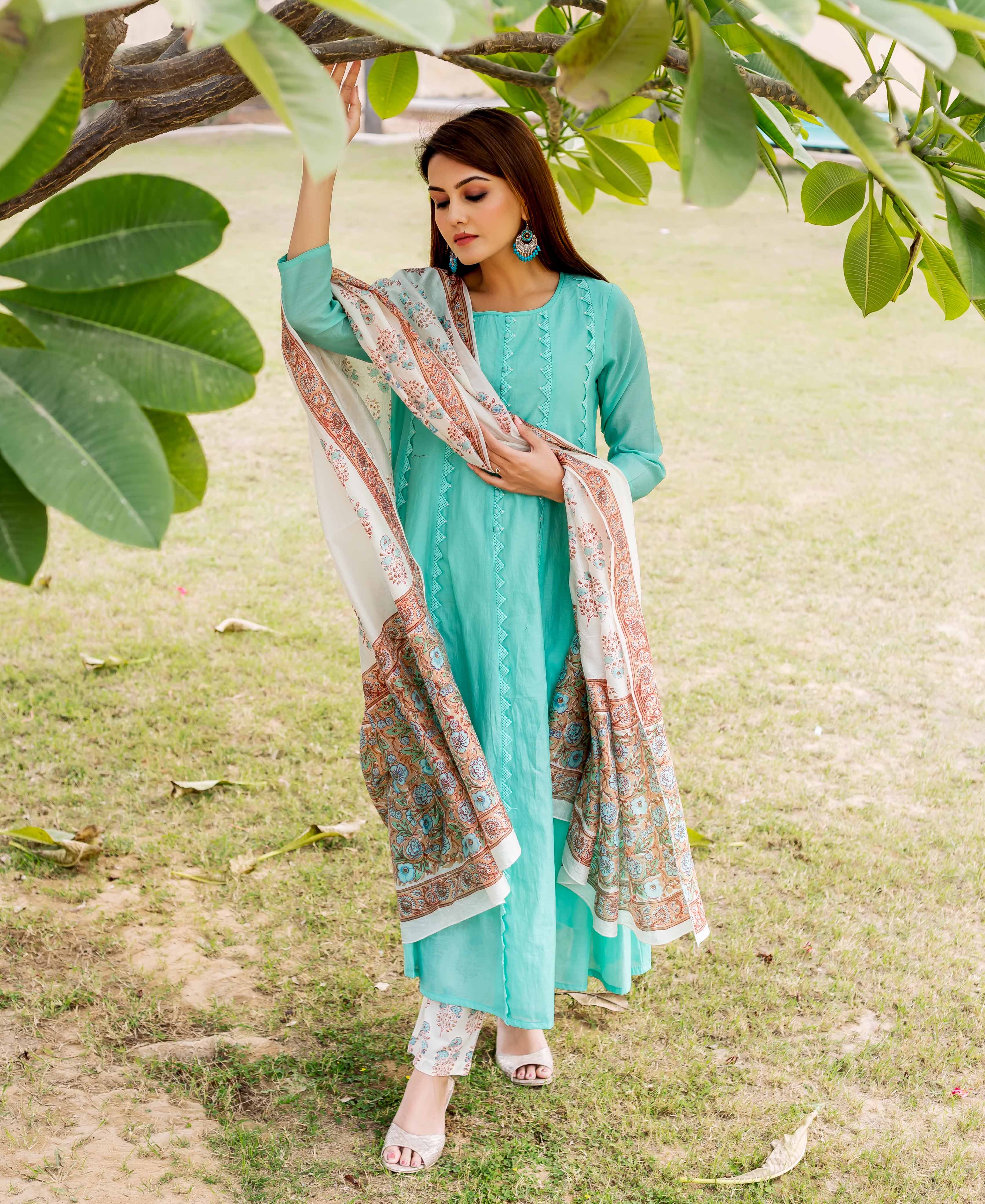 Sea green embroidered kurta on model with white and orange patterned shawl and pants.