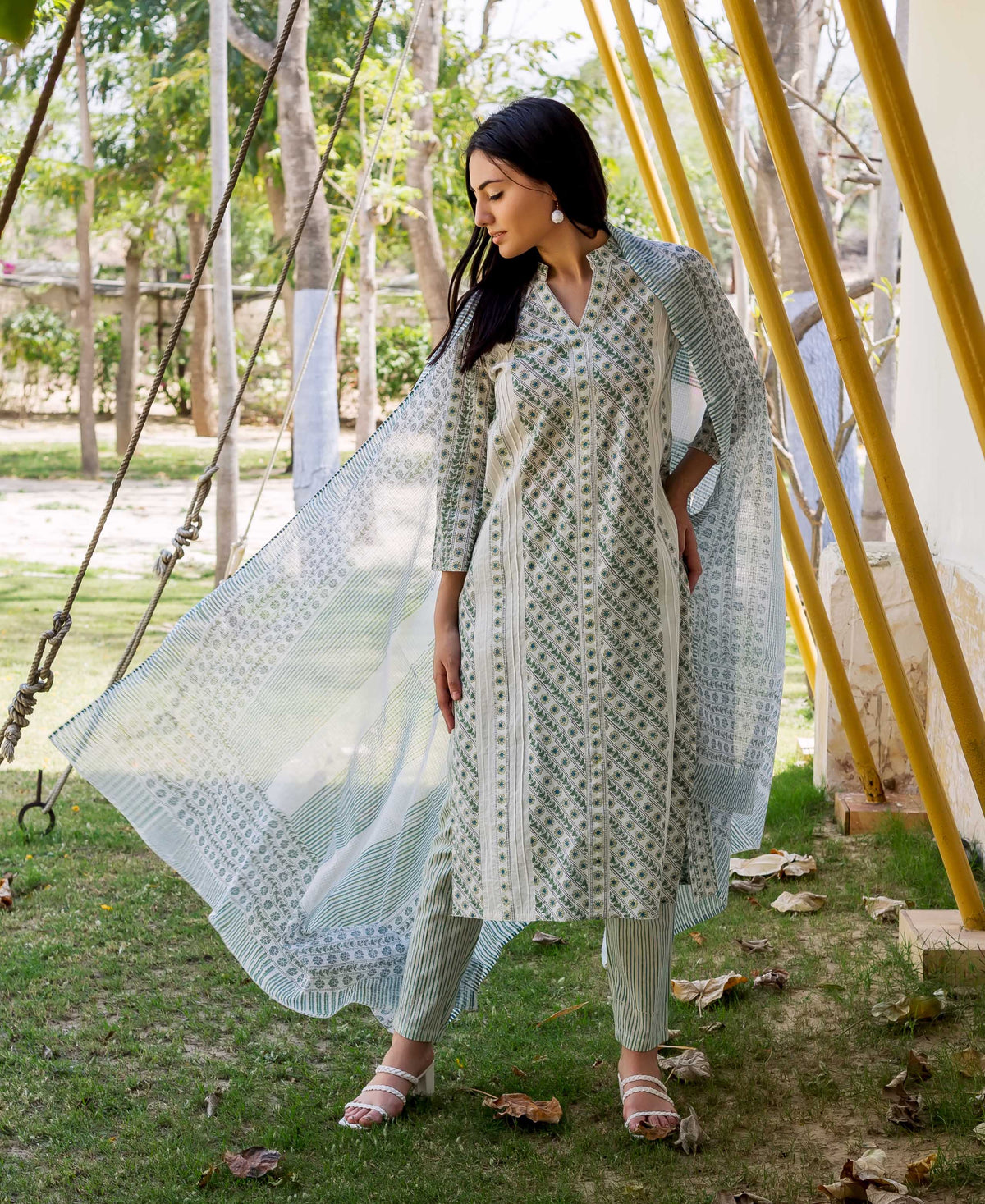 A model wearing a white and green hand-block-printed kurta with a matching dupatta.