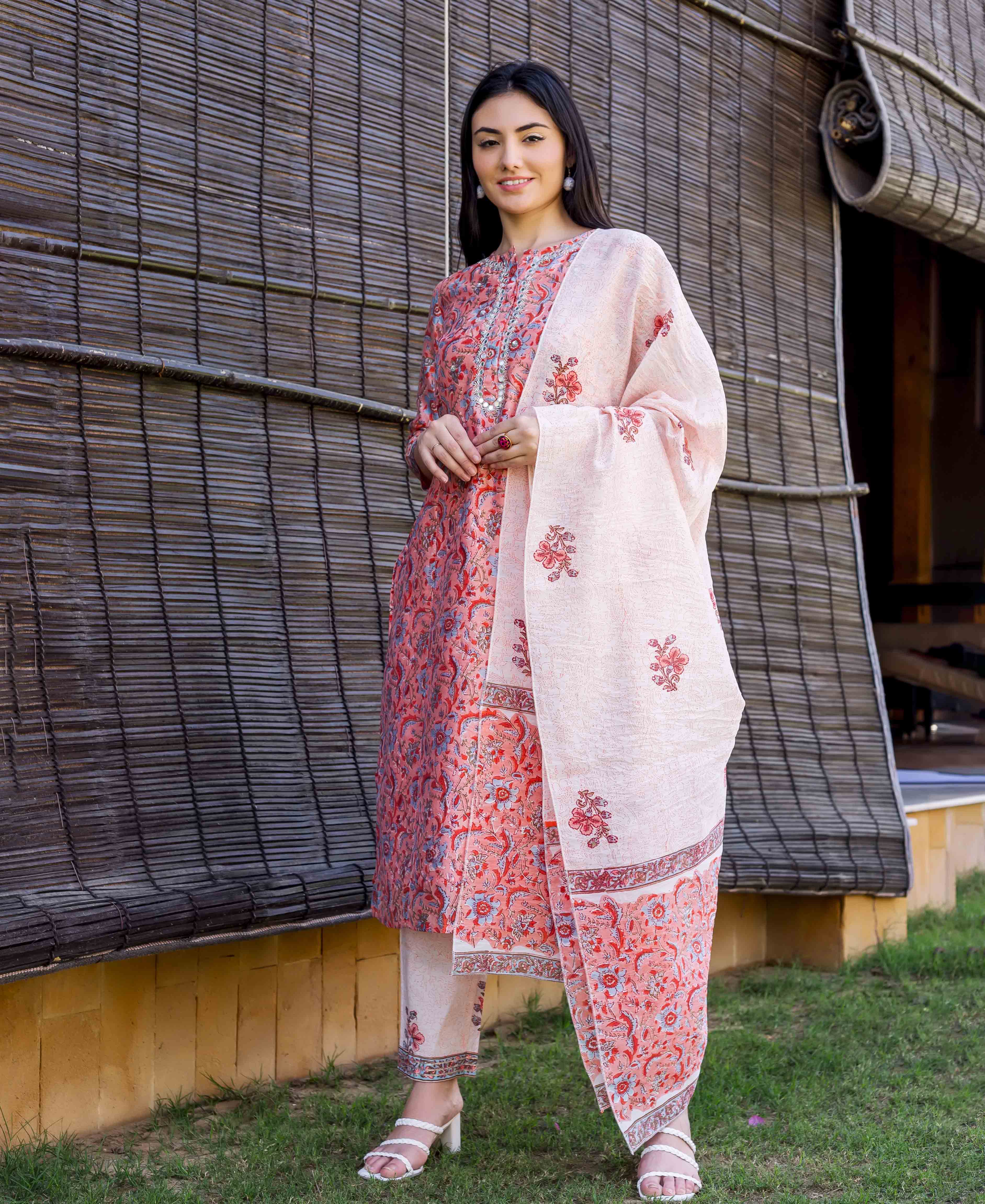 Smiling model in a peach block-printed and embroidered kurta, matching pants, and dupatta.