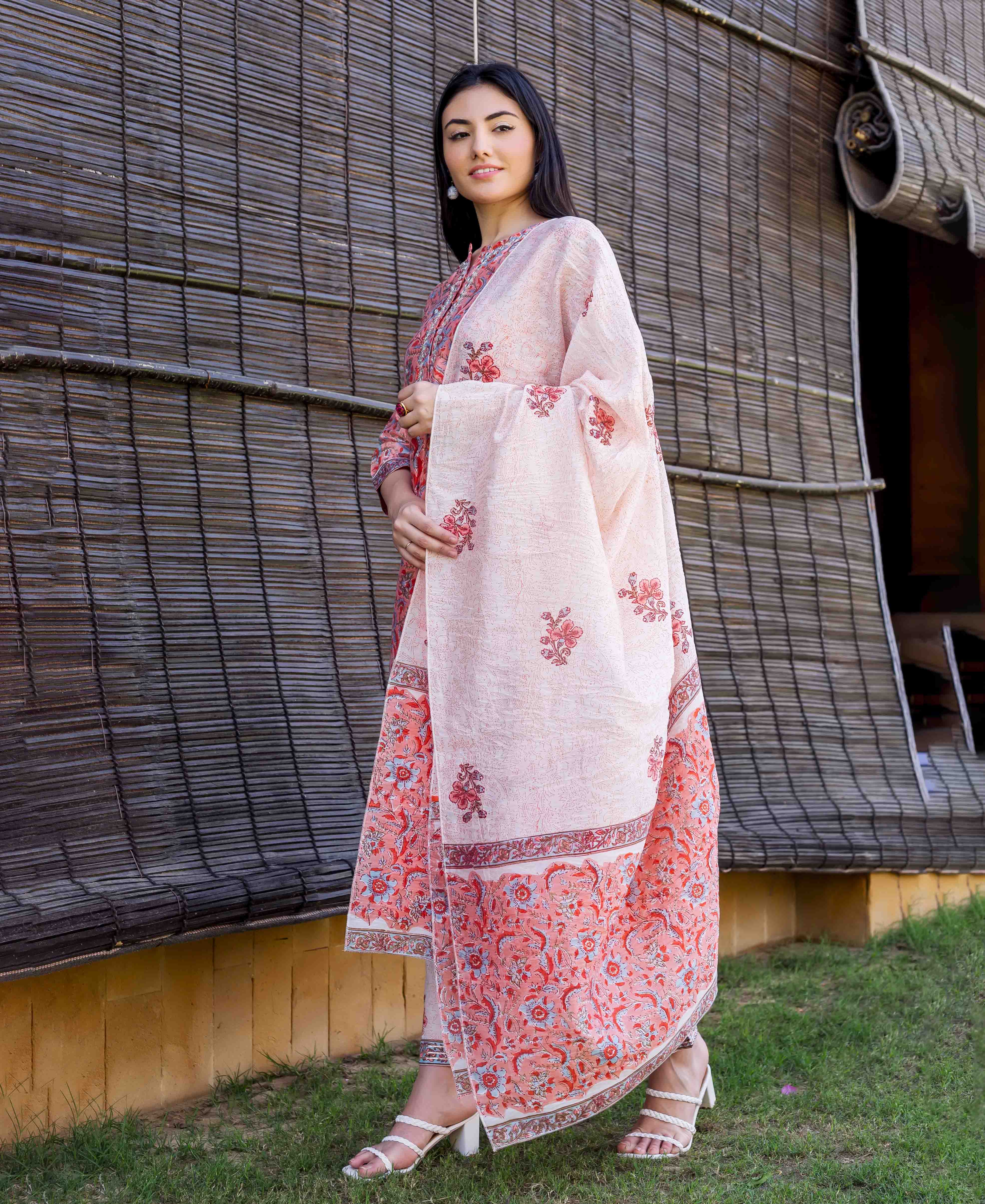 Model wearing a peach hand-block-printed kurta set with a coordinating floral dupatta, full-body view.