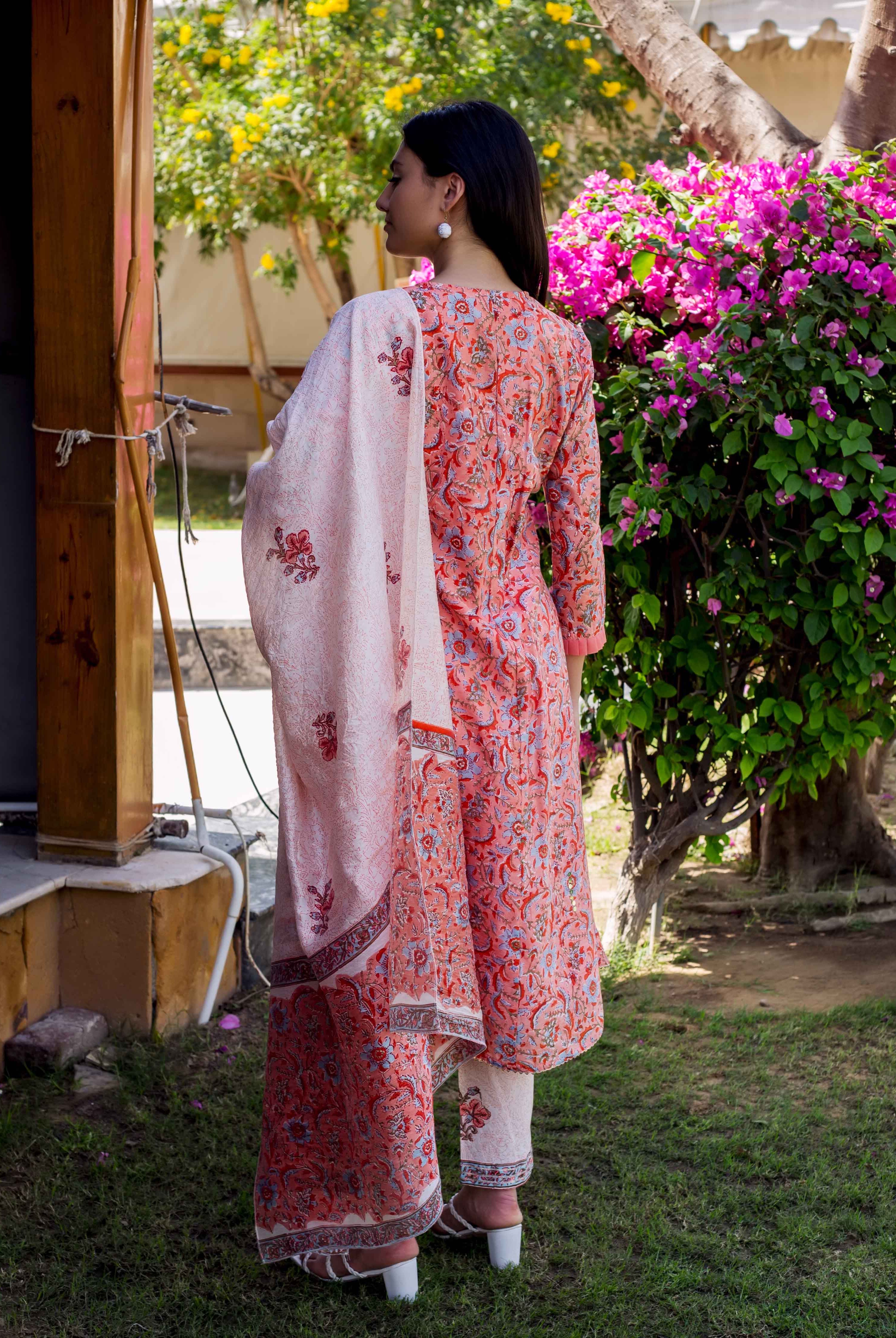 Back view of model in a peach and red floral block printed A-line kurta set.