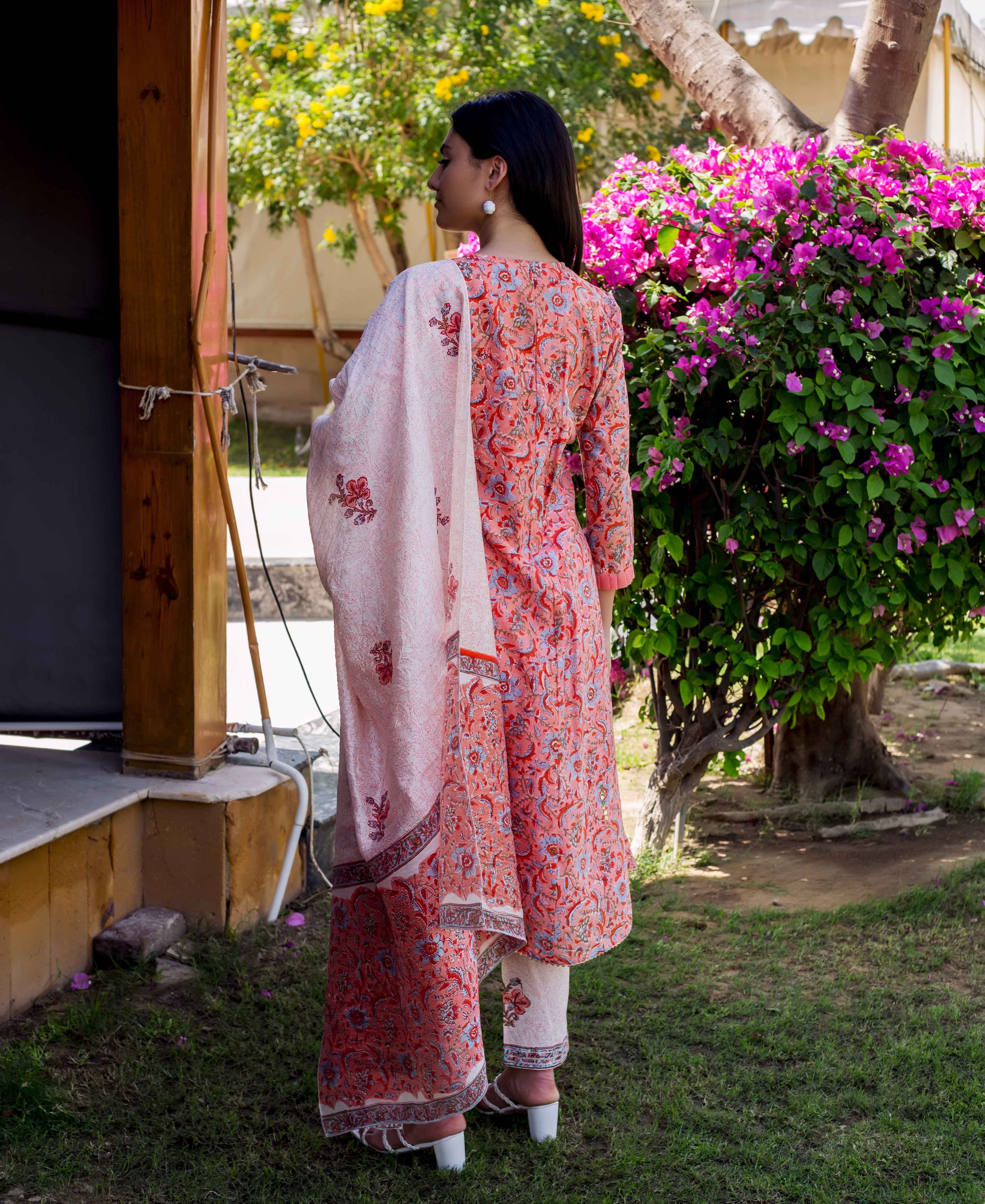 Back view of model in a peach and red floral block printed A-line kurta set.