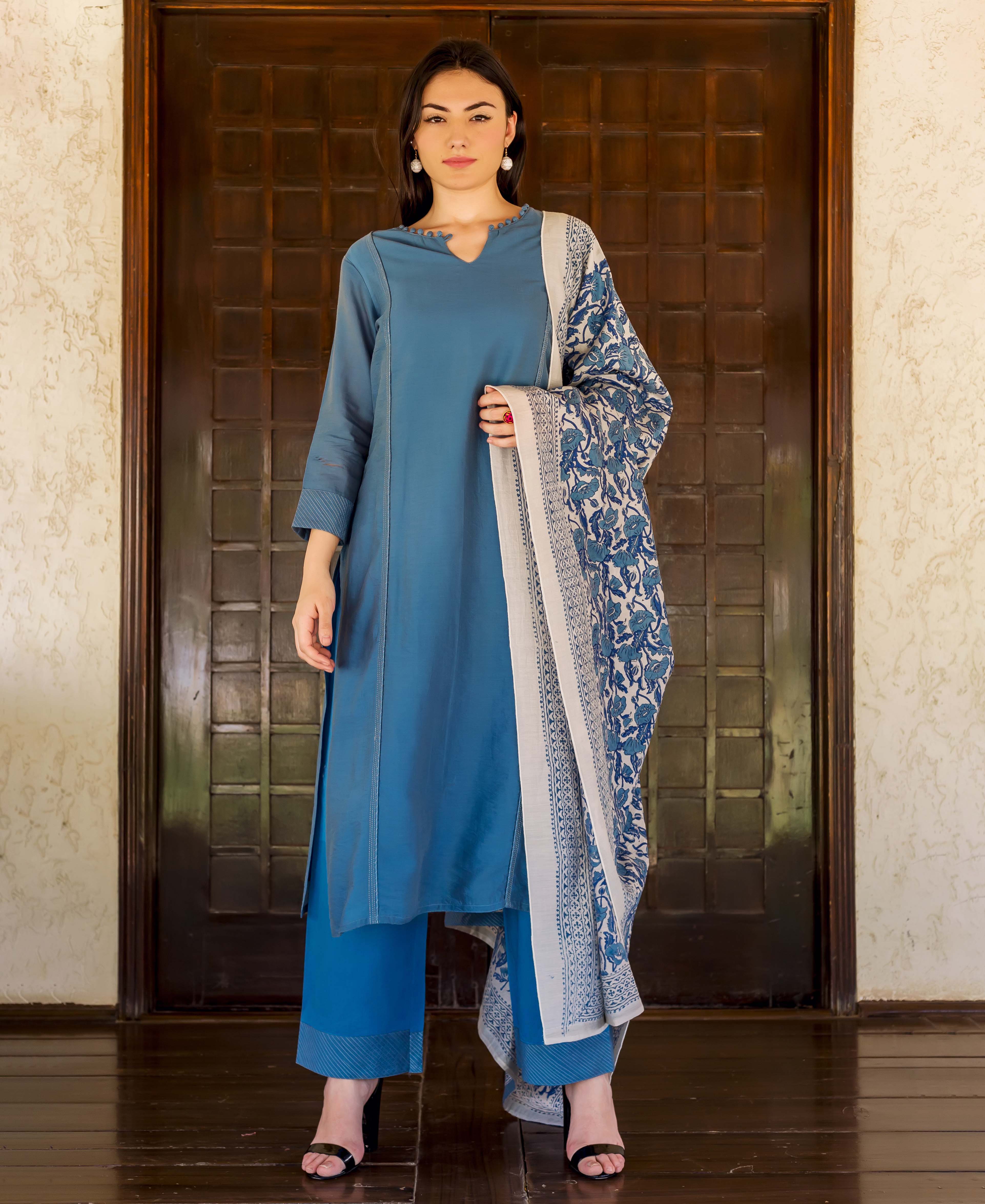 Woman models Prussian blue embroidered kurta and palazzo with a blue hand-block-printed dupatta.