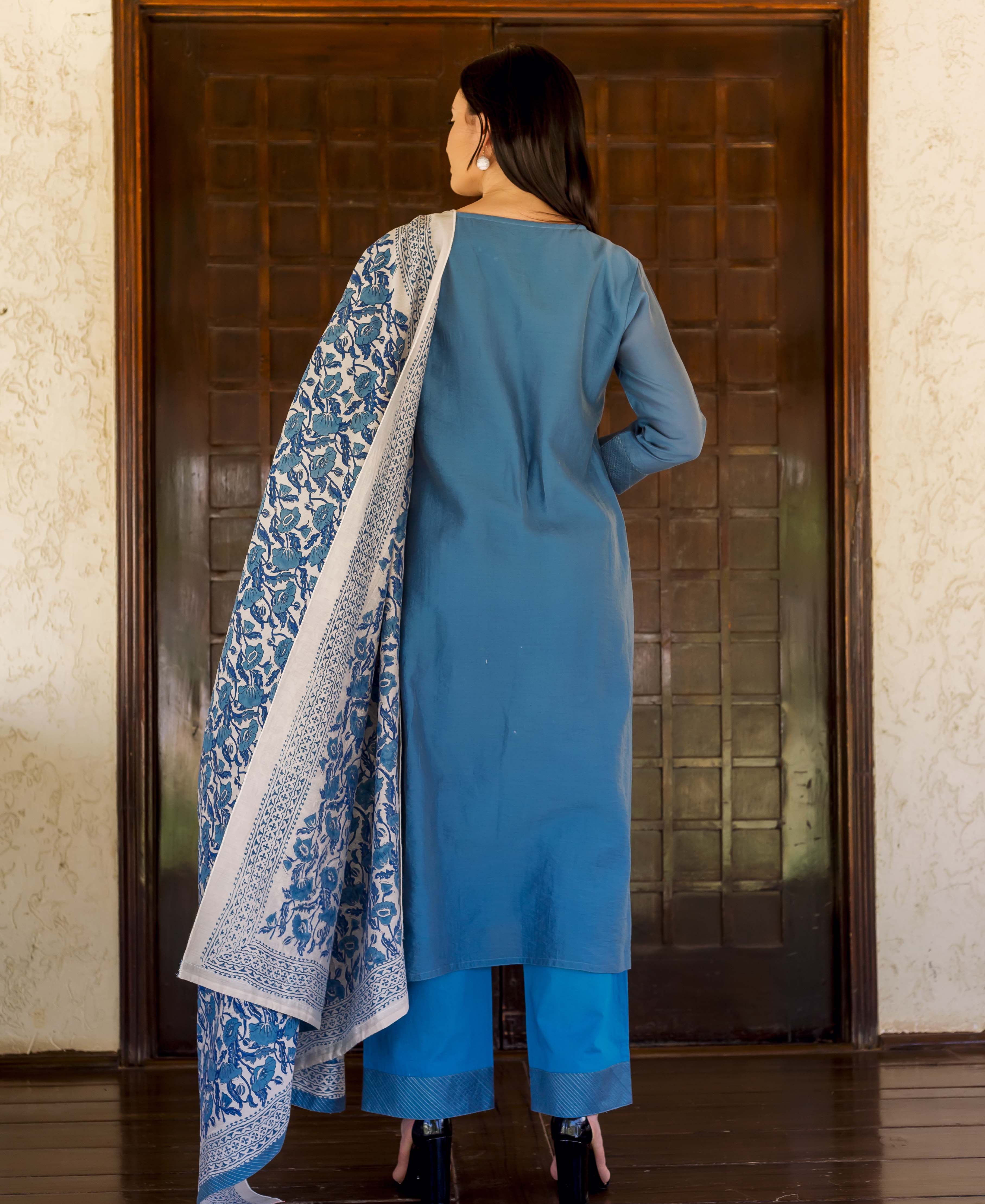 Rear view: model wearing Prussian blue kurta set with white and blue block-printed dupatta.