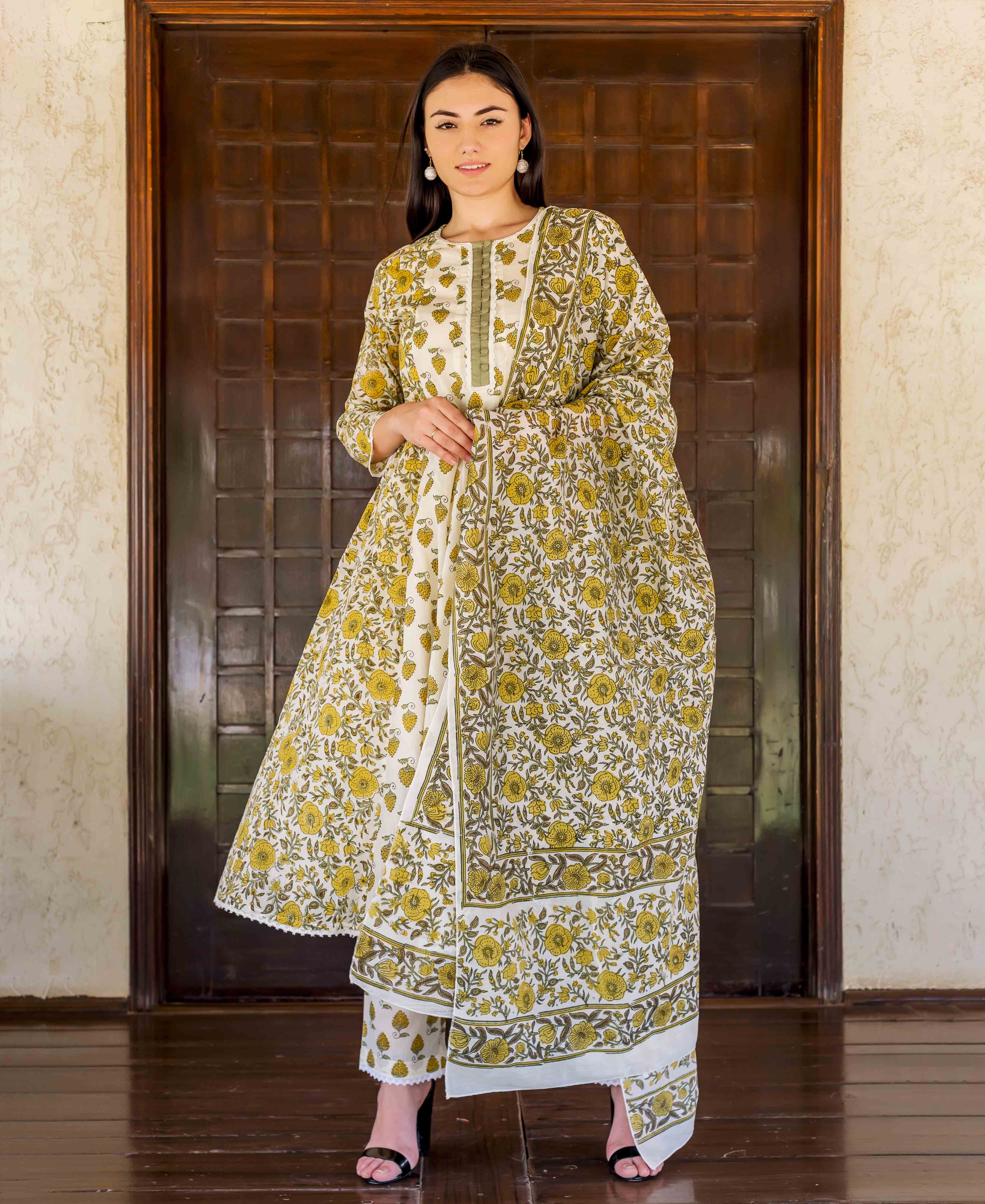 Full-length model in white A-line kurta set with ochre floral hand-block print.