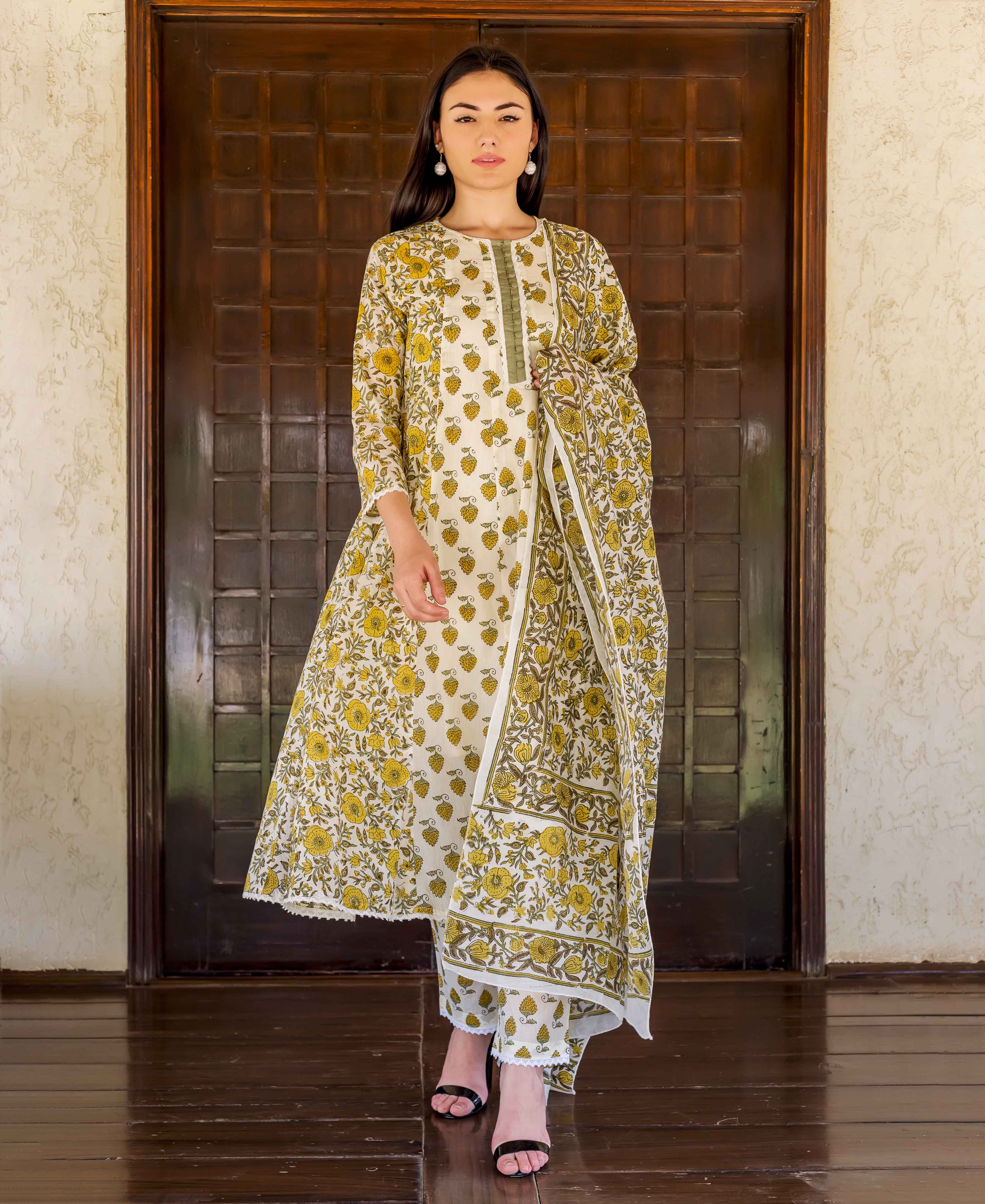 Front view model in white and ochre hand block printed A-line kurta set.