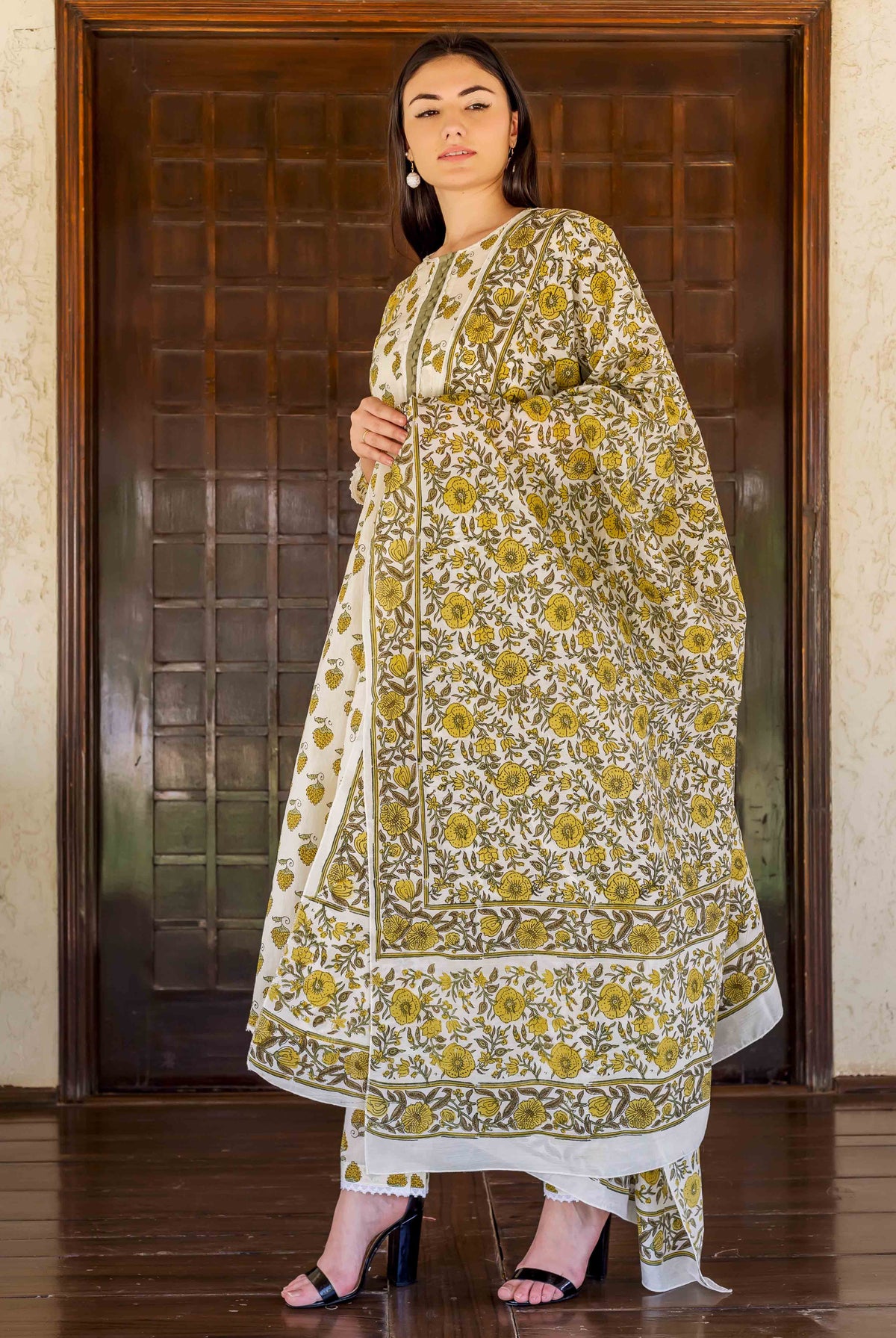 Model in a white and ochre hand block printed floral A-line kurta set.