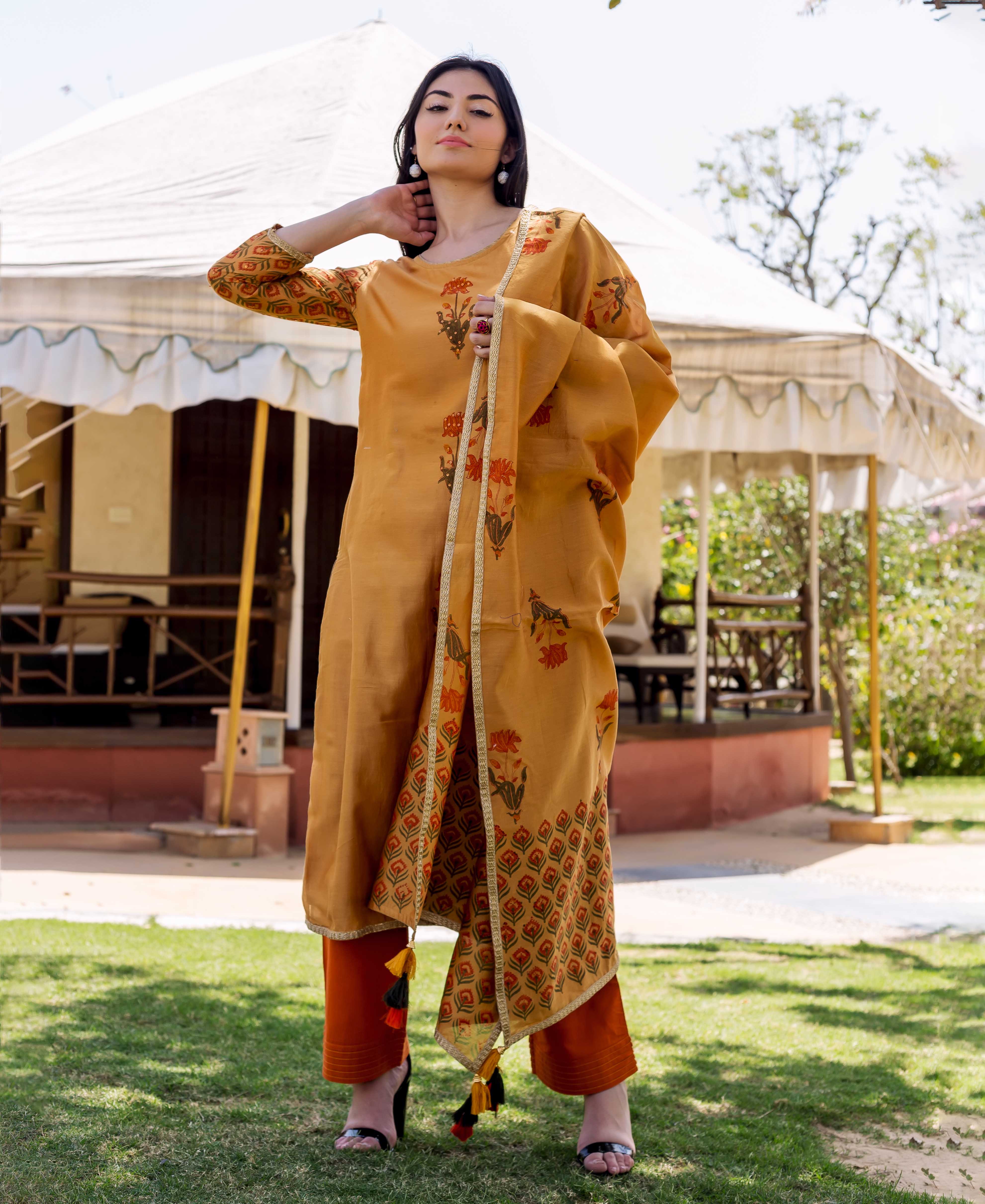 Model in mustard yellow hand-block printed kurta set with floral and geometric patterns.