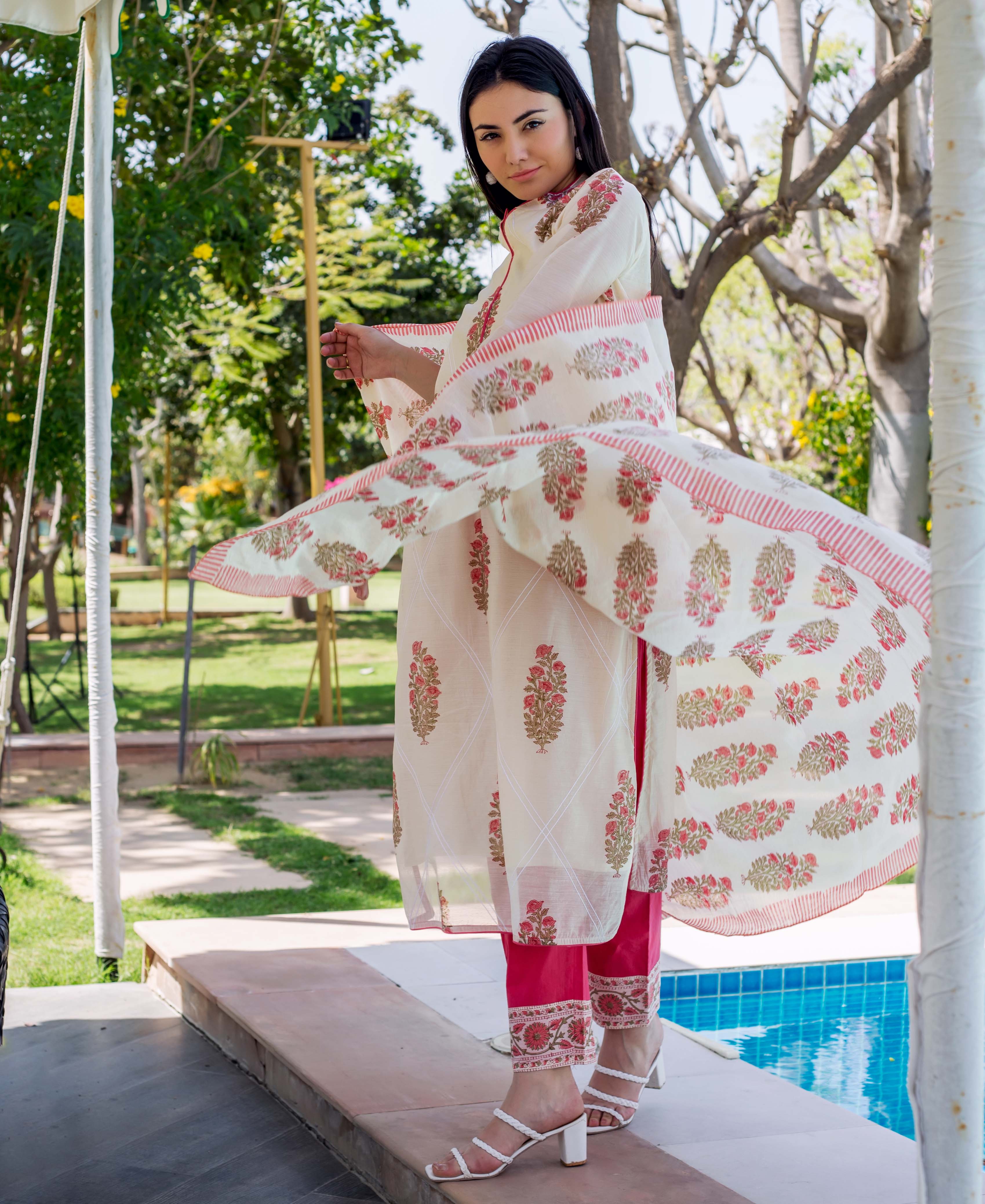 Model in cream floral block print kurta, dupatta, and hot pink trousers.