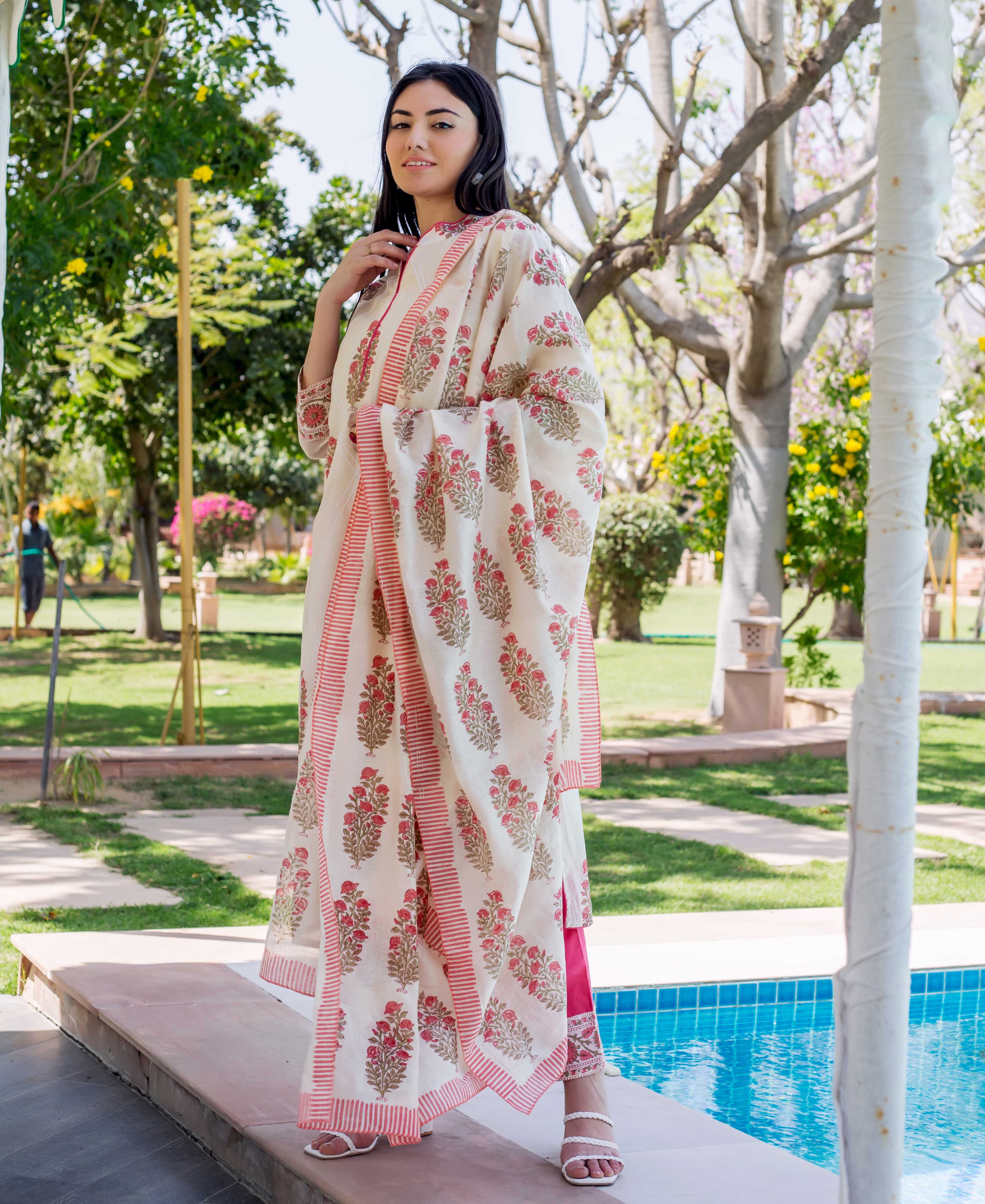 Model in cream hand-block-printed ethnic kurta set with red floral print and striped dupatta.