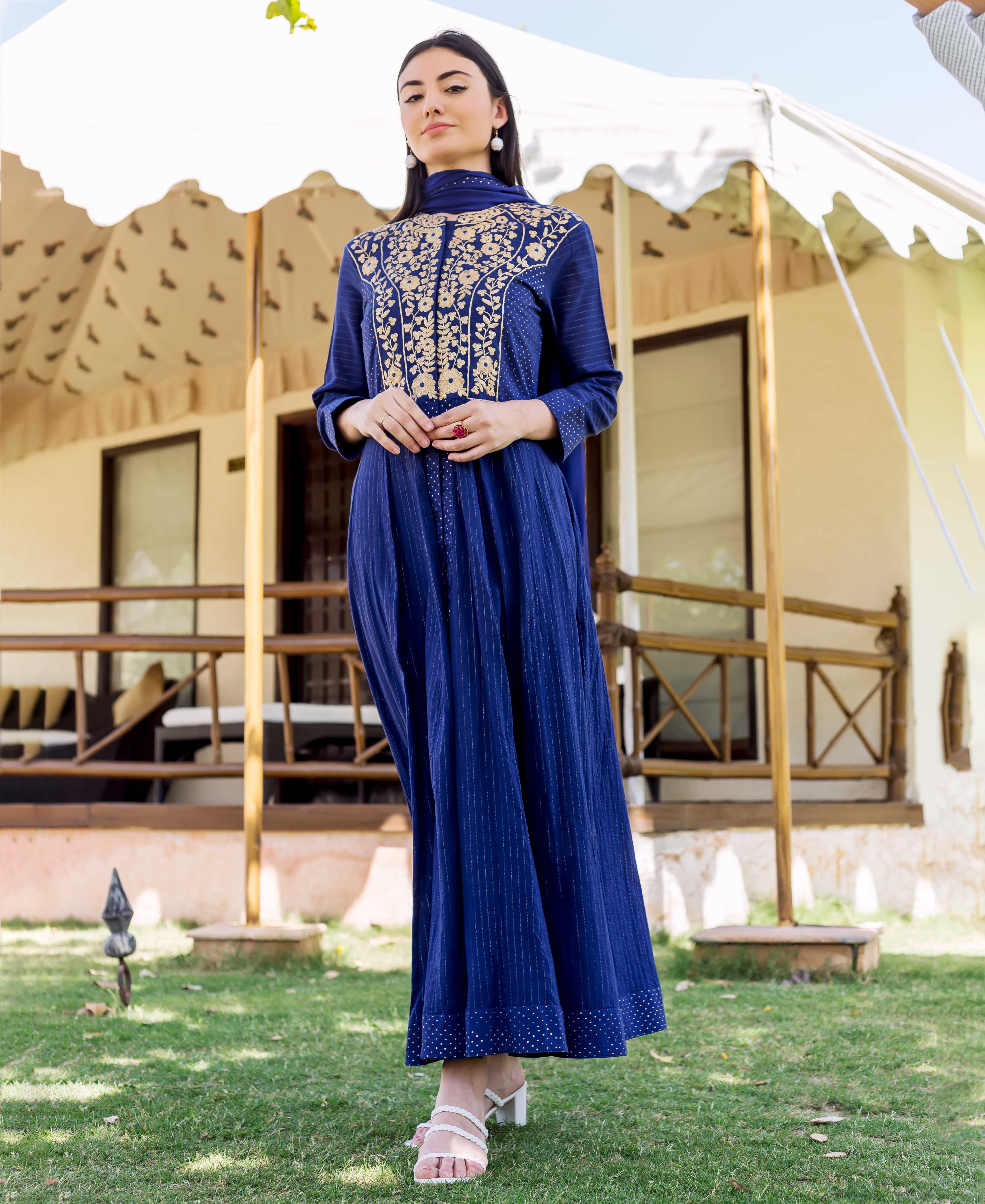 Full front view of model in royal blue maxi dress with gold embroidery and print.
