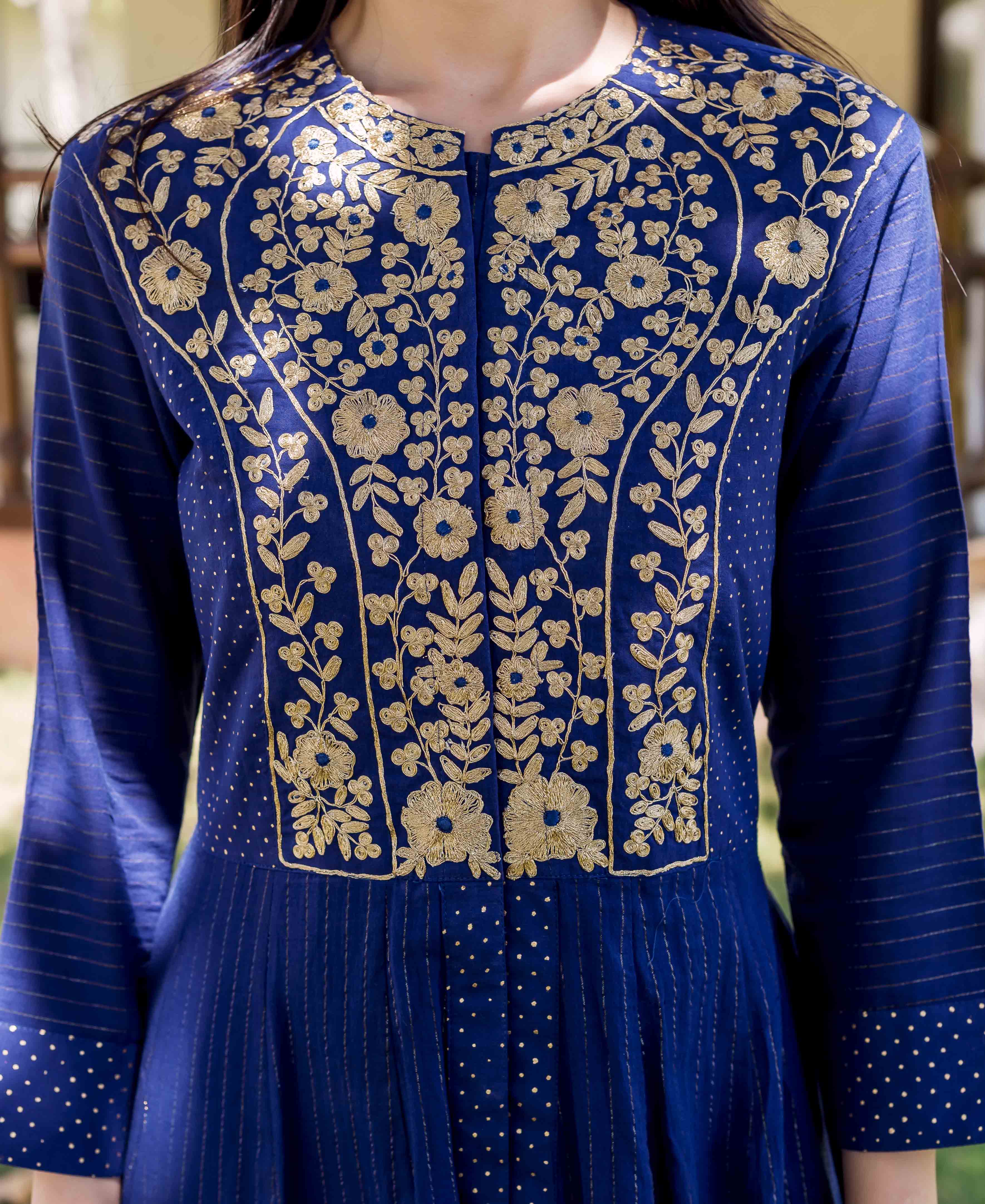 A model wearing a royal blue dress with gold embroidery and block print.