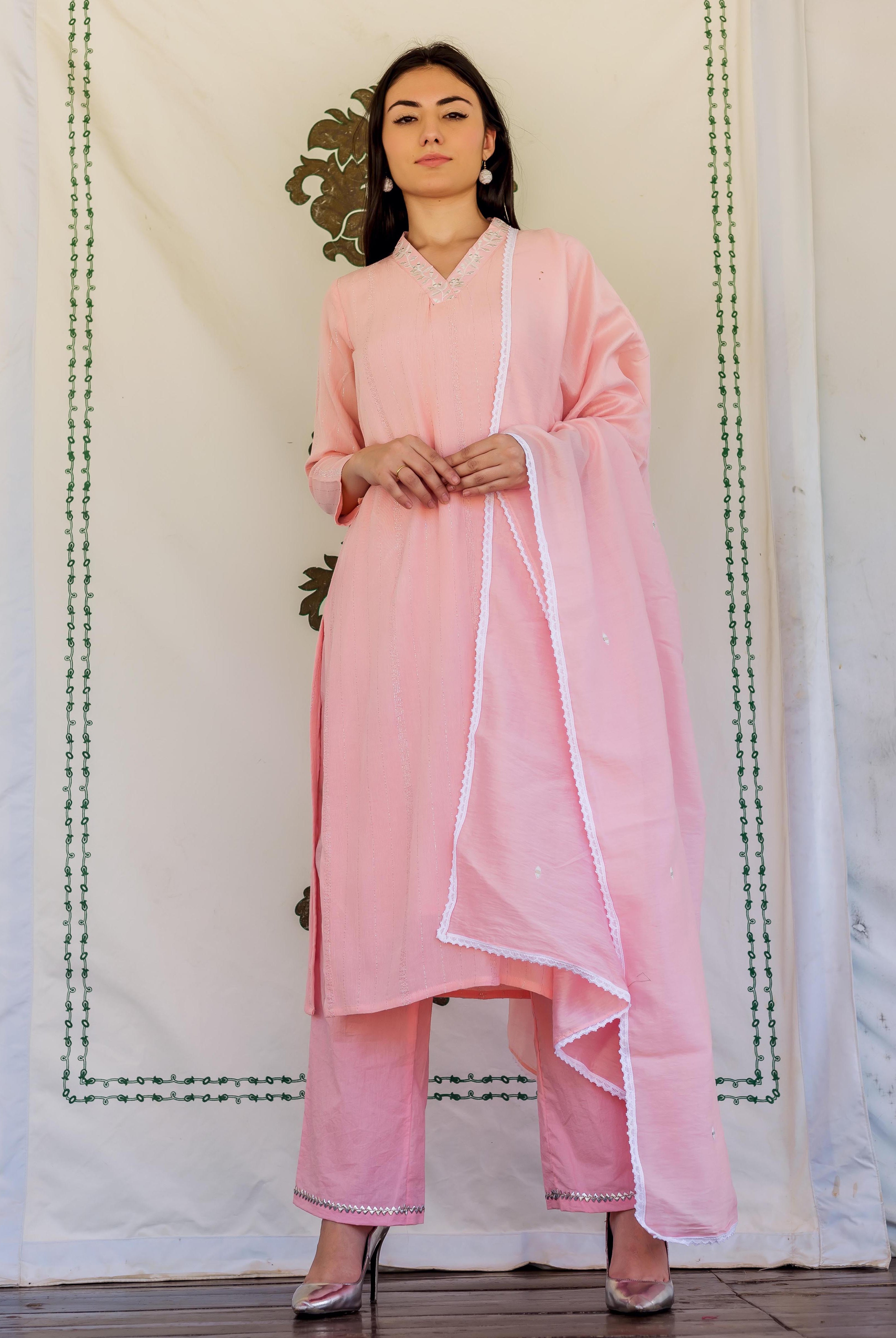 Full-length front view of model in light pink embroidered kurta set with white lace.