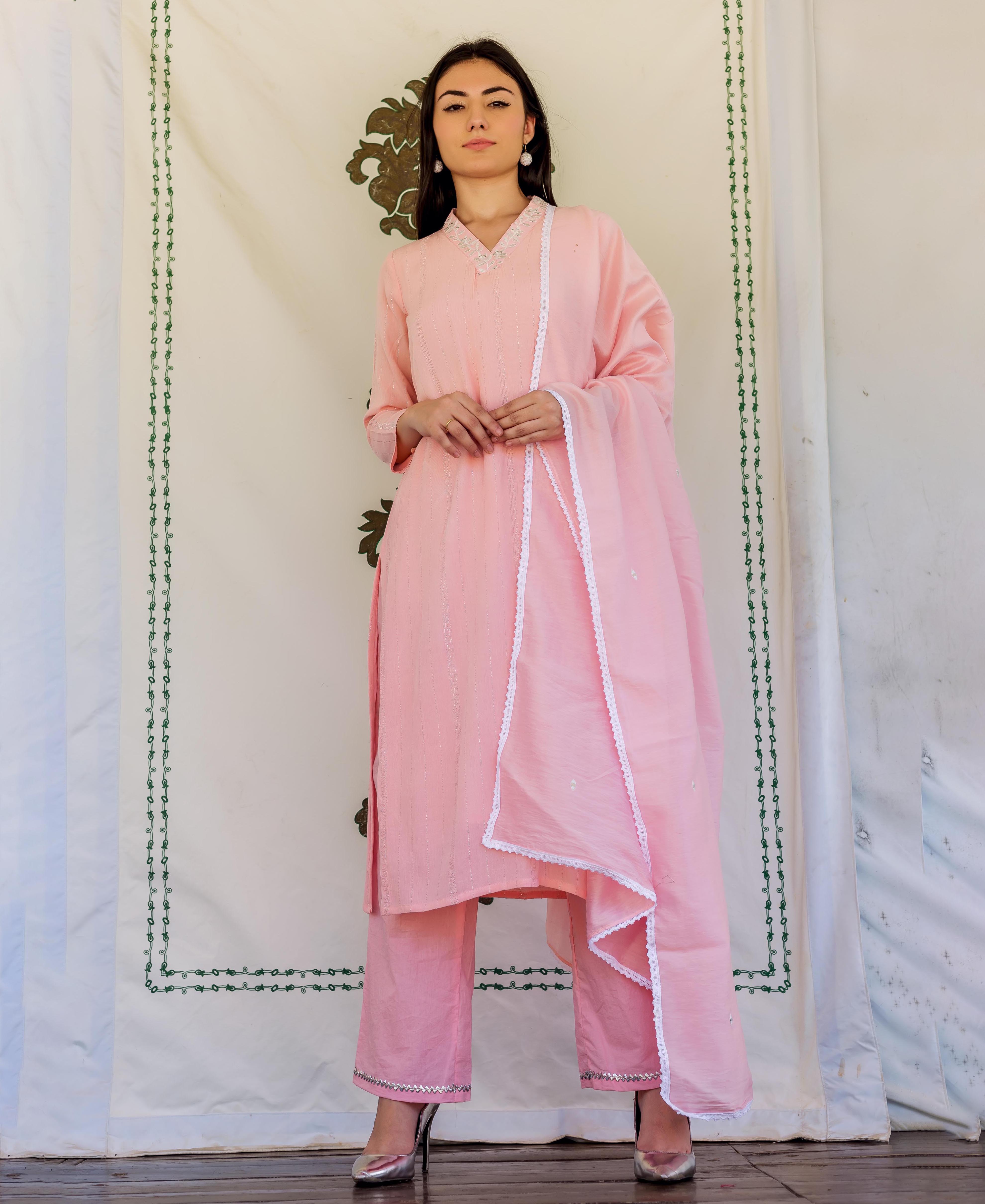Full-length front view of model in light pink embroidered kurta set with white lace.