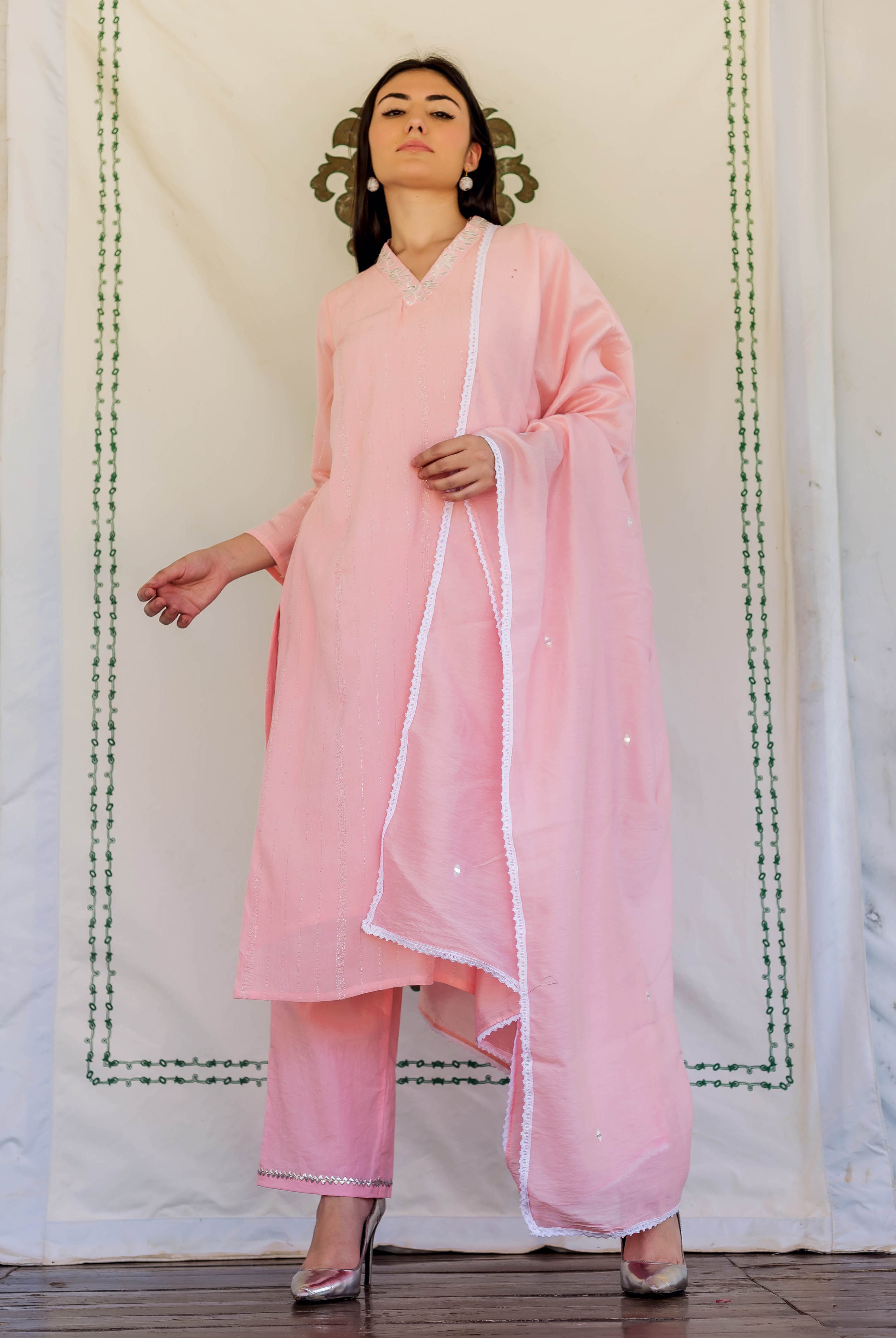 A model wearing a pink kurta with white embroidery and a matching dupatta.