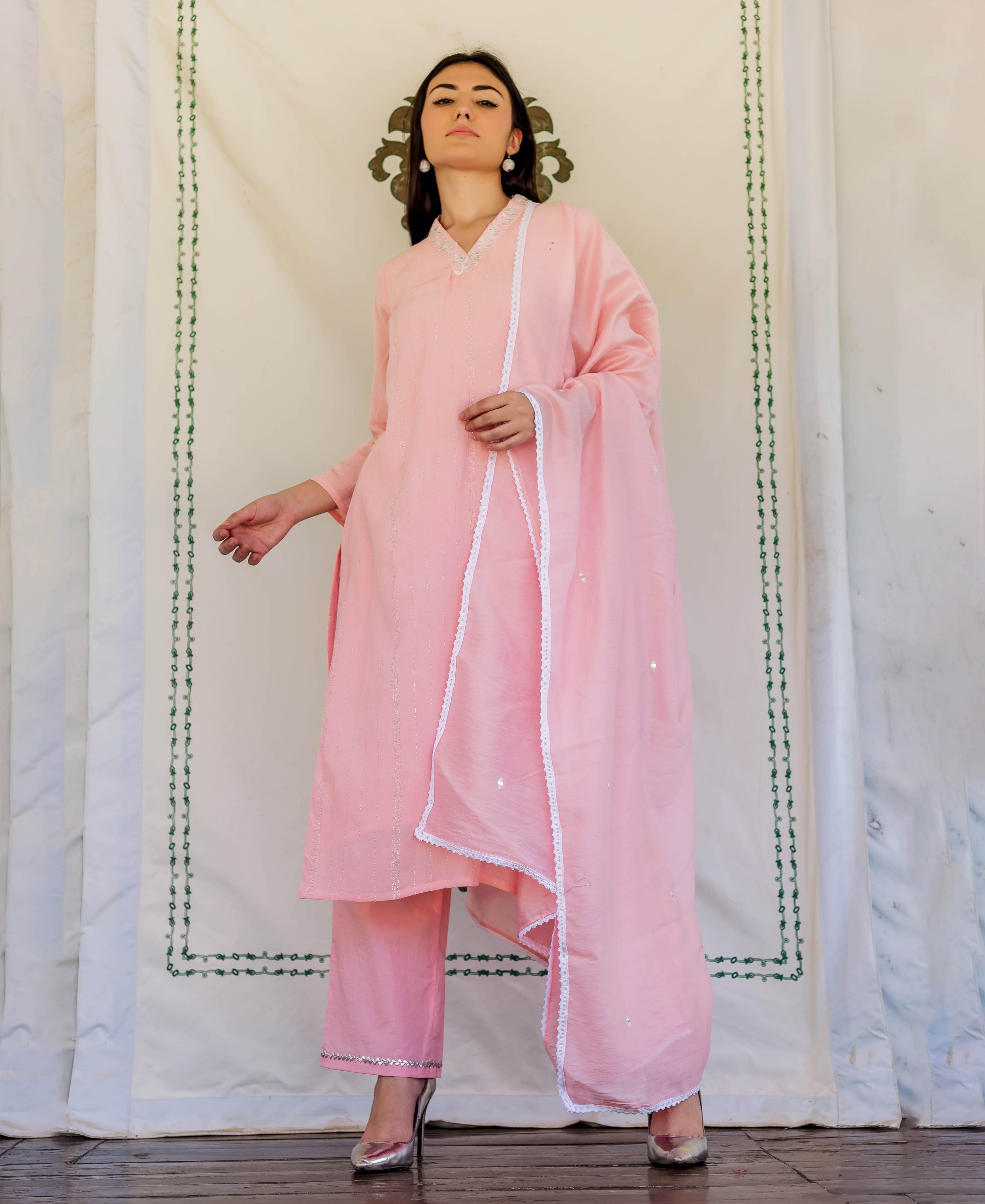 A model wearing a pink kurta with white embroidery and a matching dupatta.