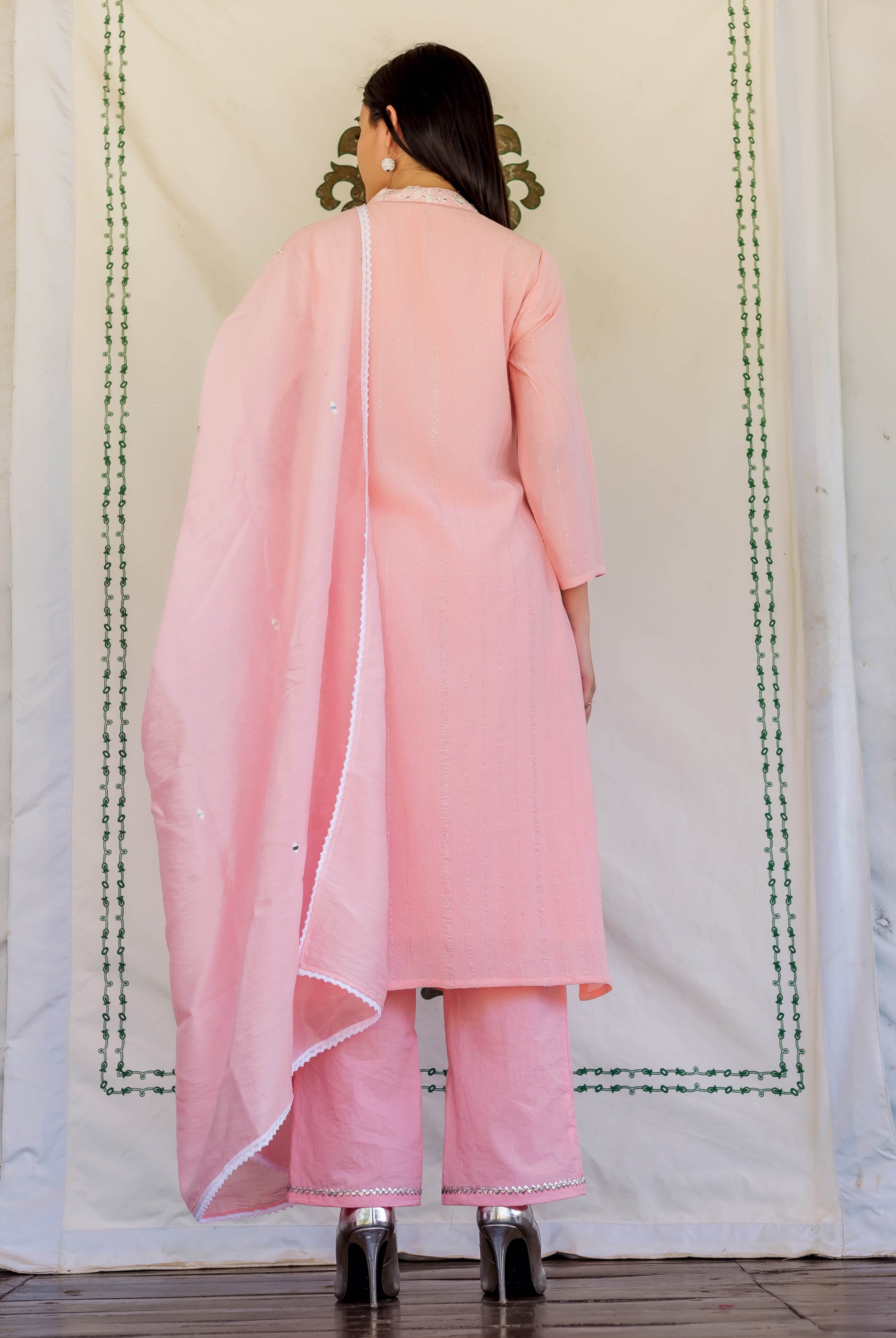 Back view of model in pink embroidered kurta set with matching dupatta.