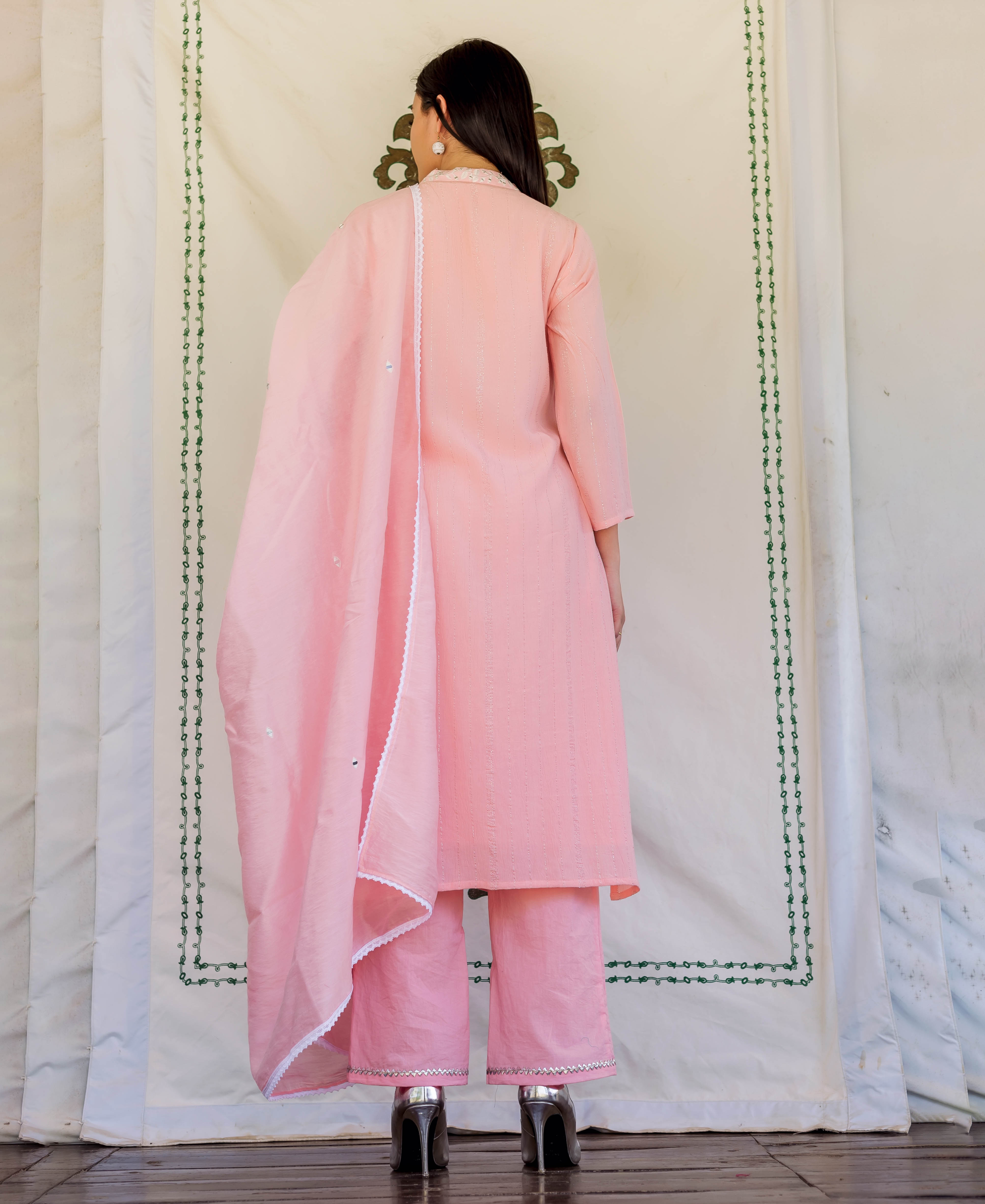 Back view of model in pink embroidered kurta set with matching dupatta.