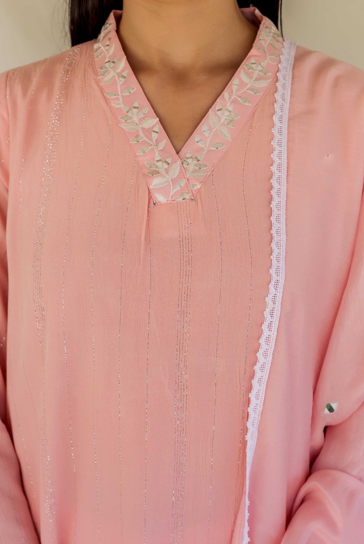 Pink straight kurta on model, featuring an embroidered V-neckline and shimmering vertical silver stripes.