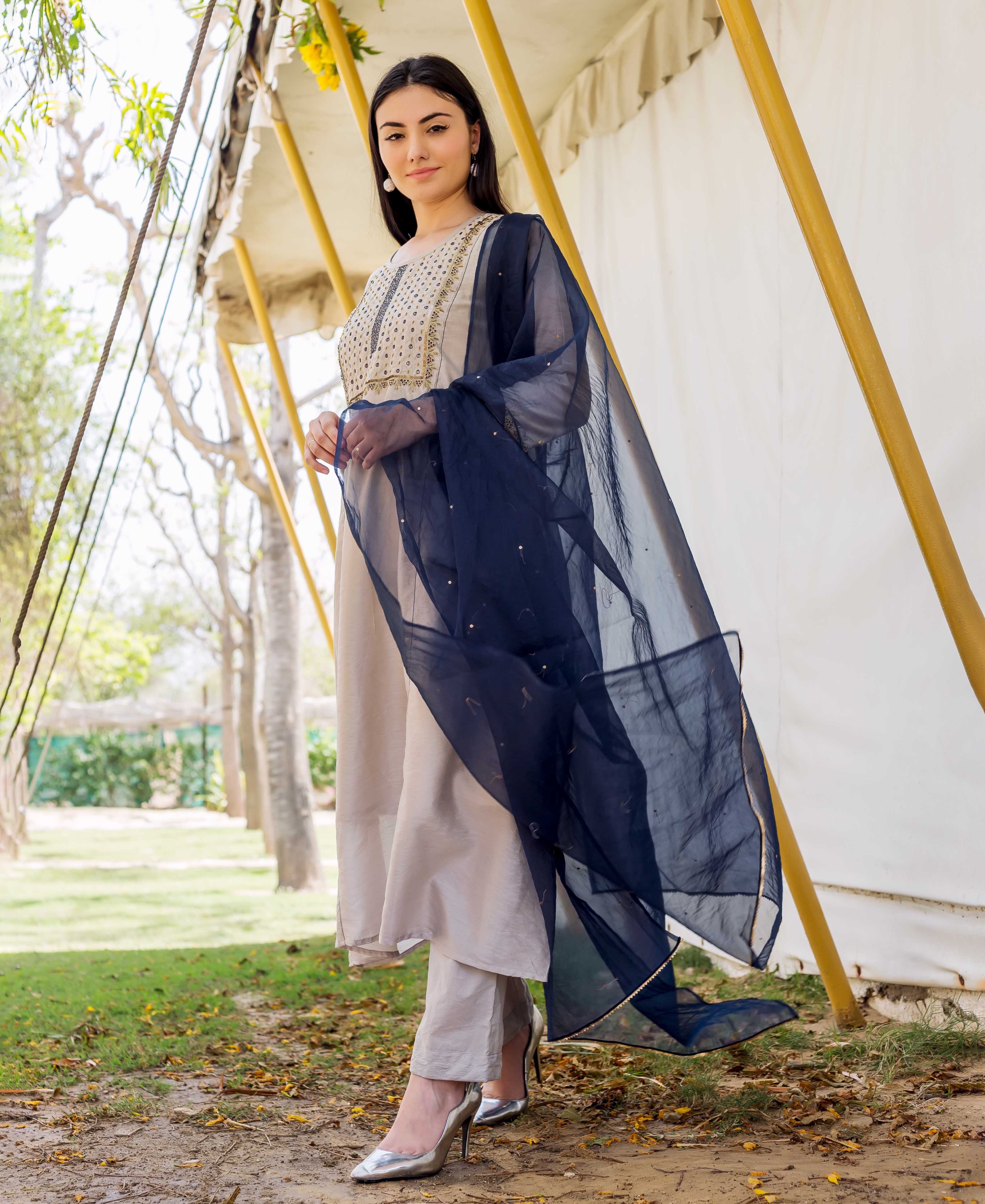 Model wears Imara grey embroidered kurta, matching pants, and a flowy navy blue dupatta.
