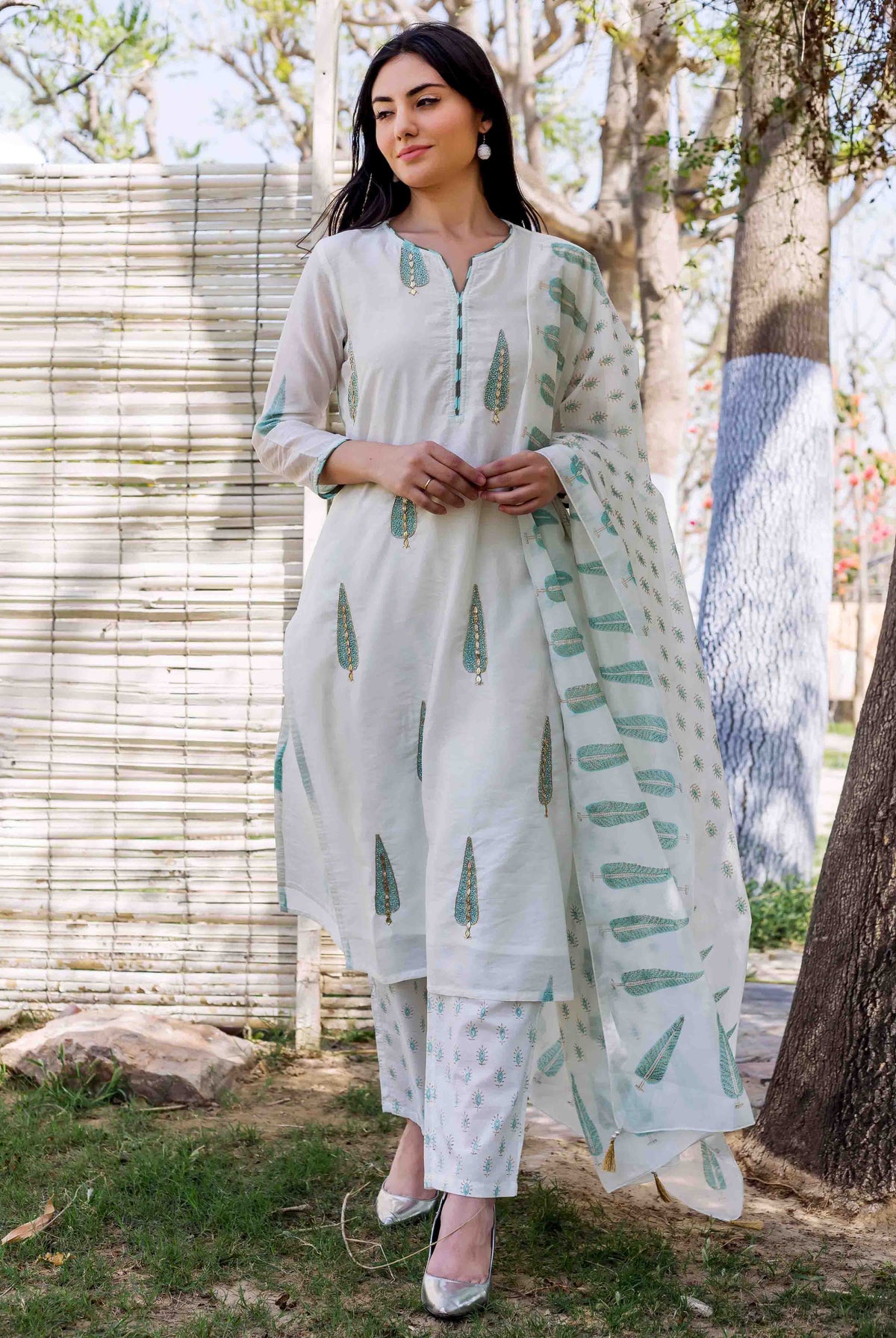 Model in white embroidered hand-block printed straight kurta set with teal motifs.
