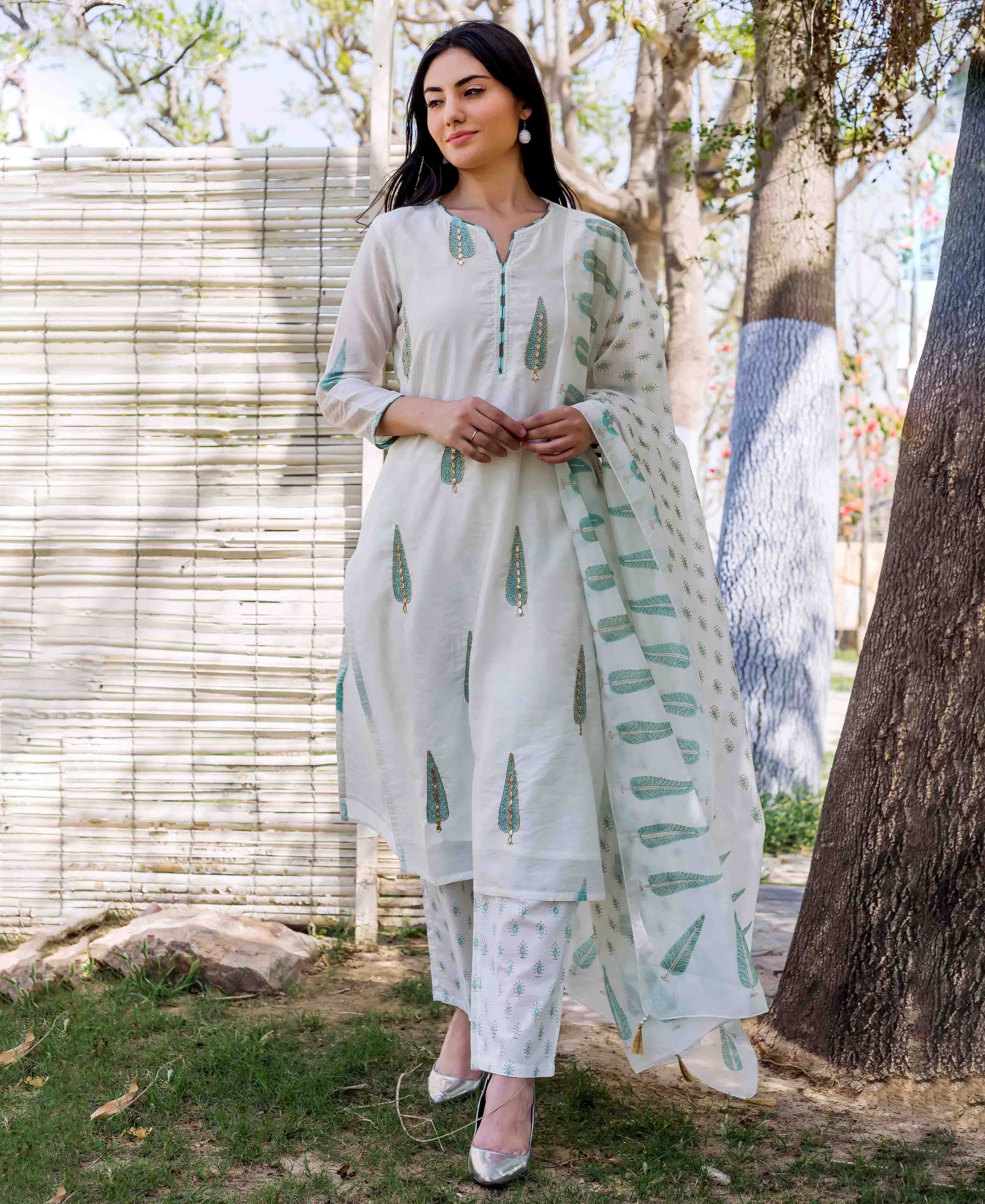 Model in white embroidered hand-block printed straight kurta set with teal motifs.