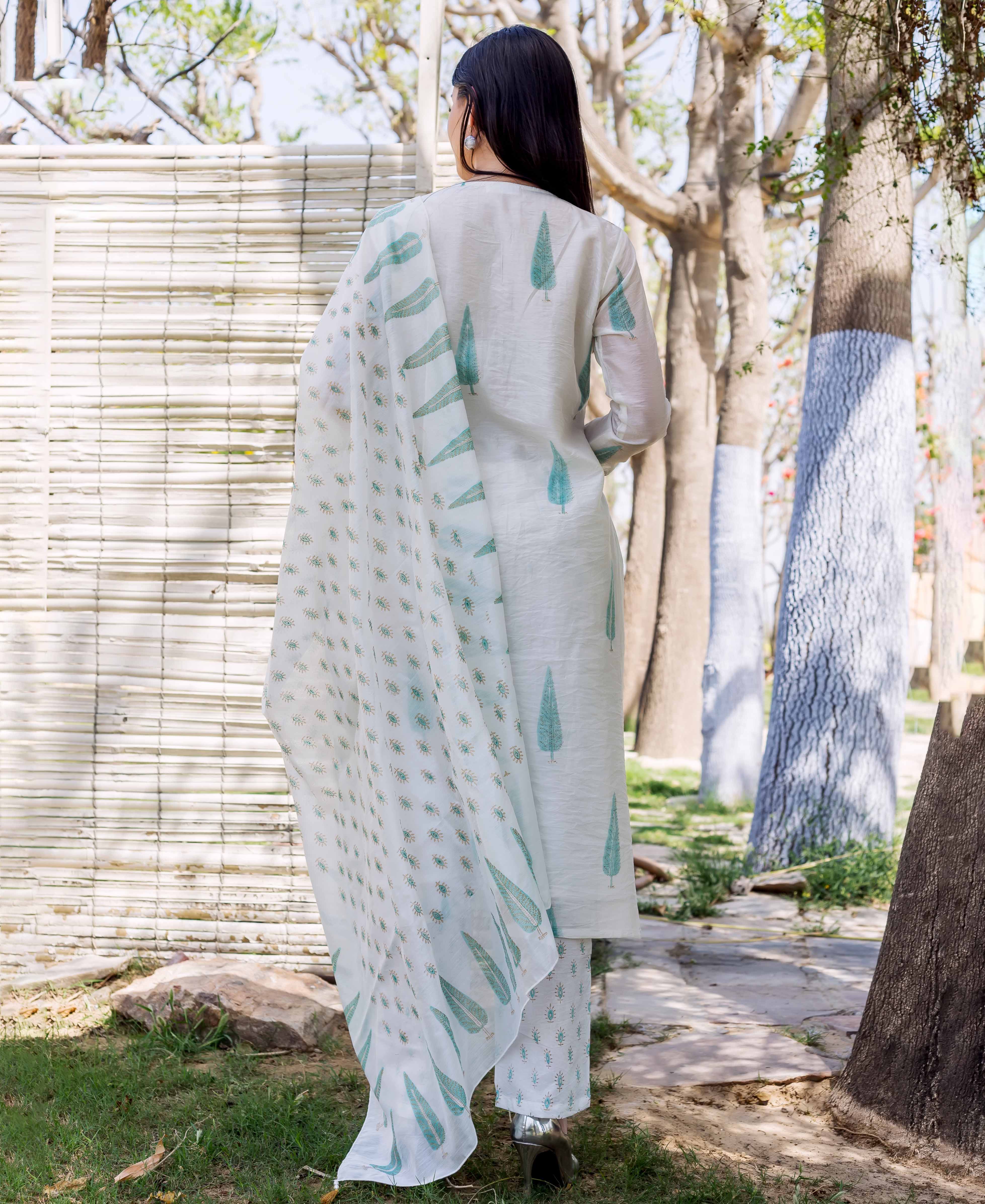 A woman in a white and green hand-block-printed kurta with a matching dupatta.