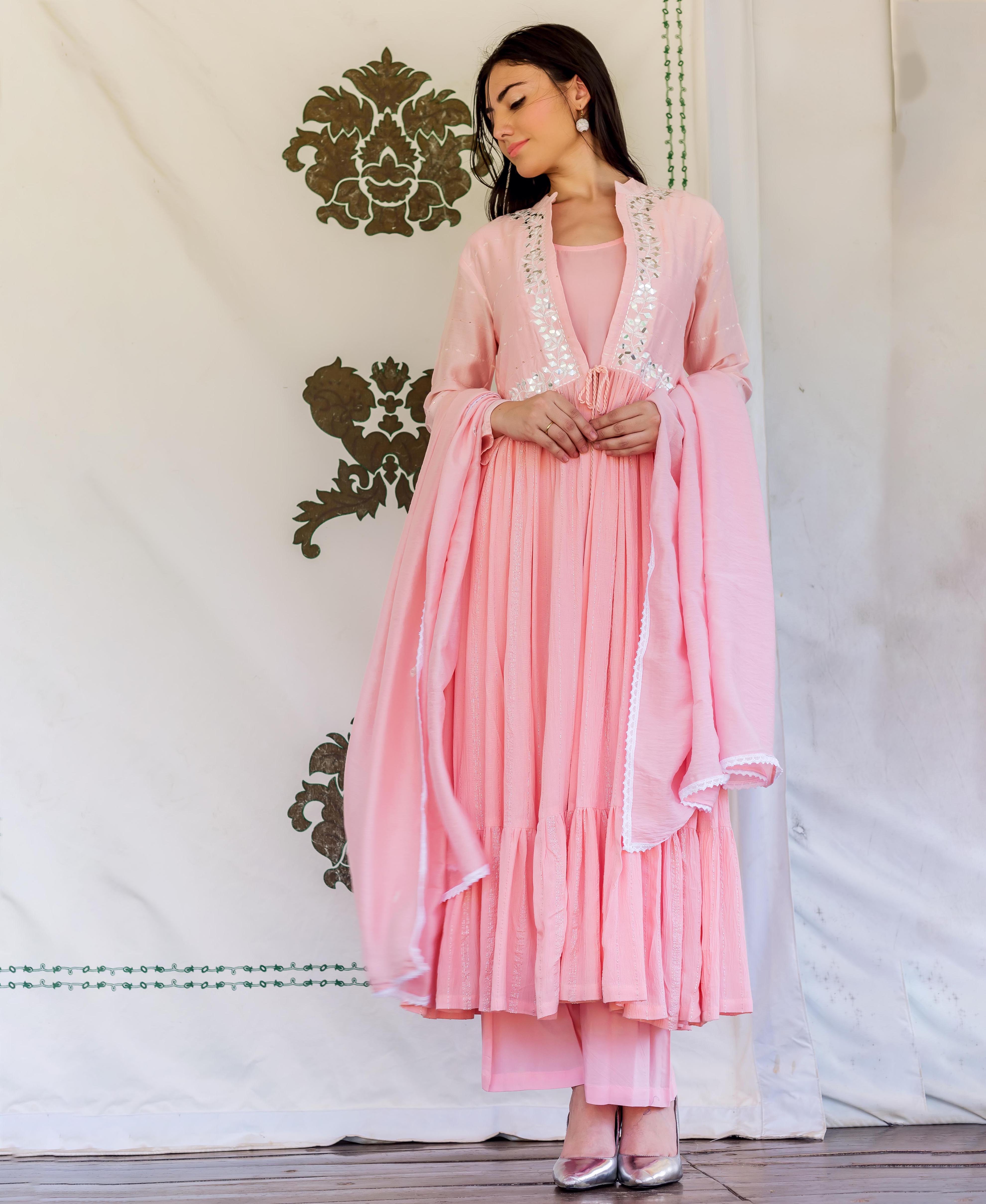 Flamingo pink embroidered kurta set on model, with a white embellished short jacket.