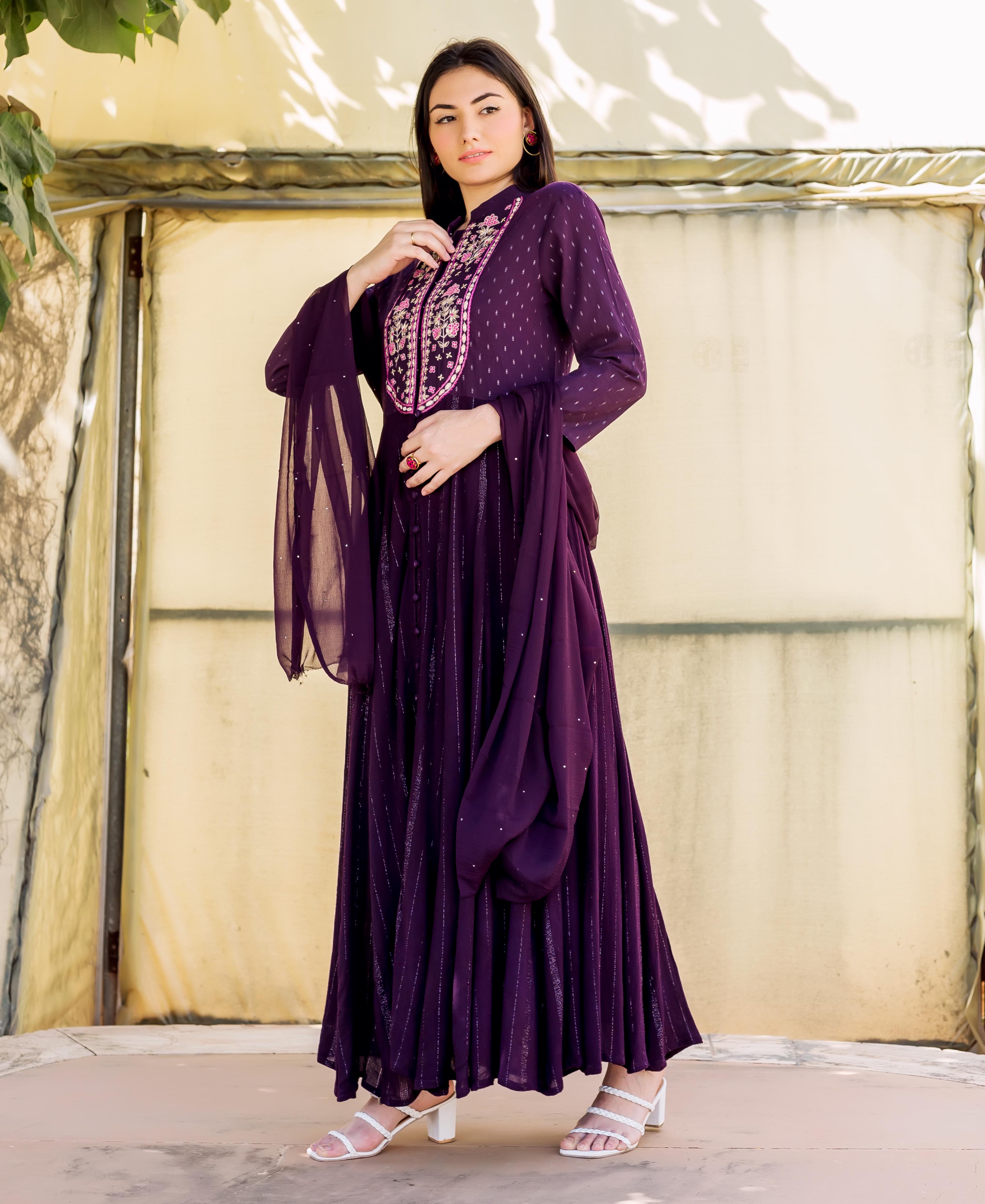 Model wears full-length wine lurex Anarkali dress with embroidered yoke and sheer dupatta.