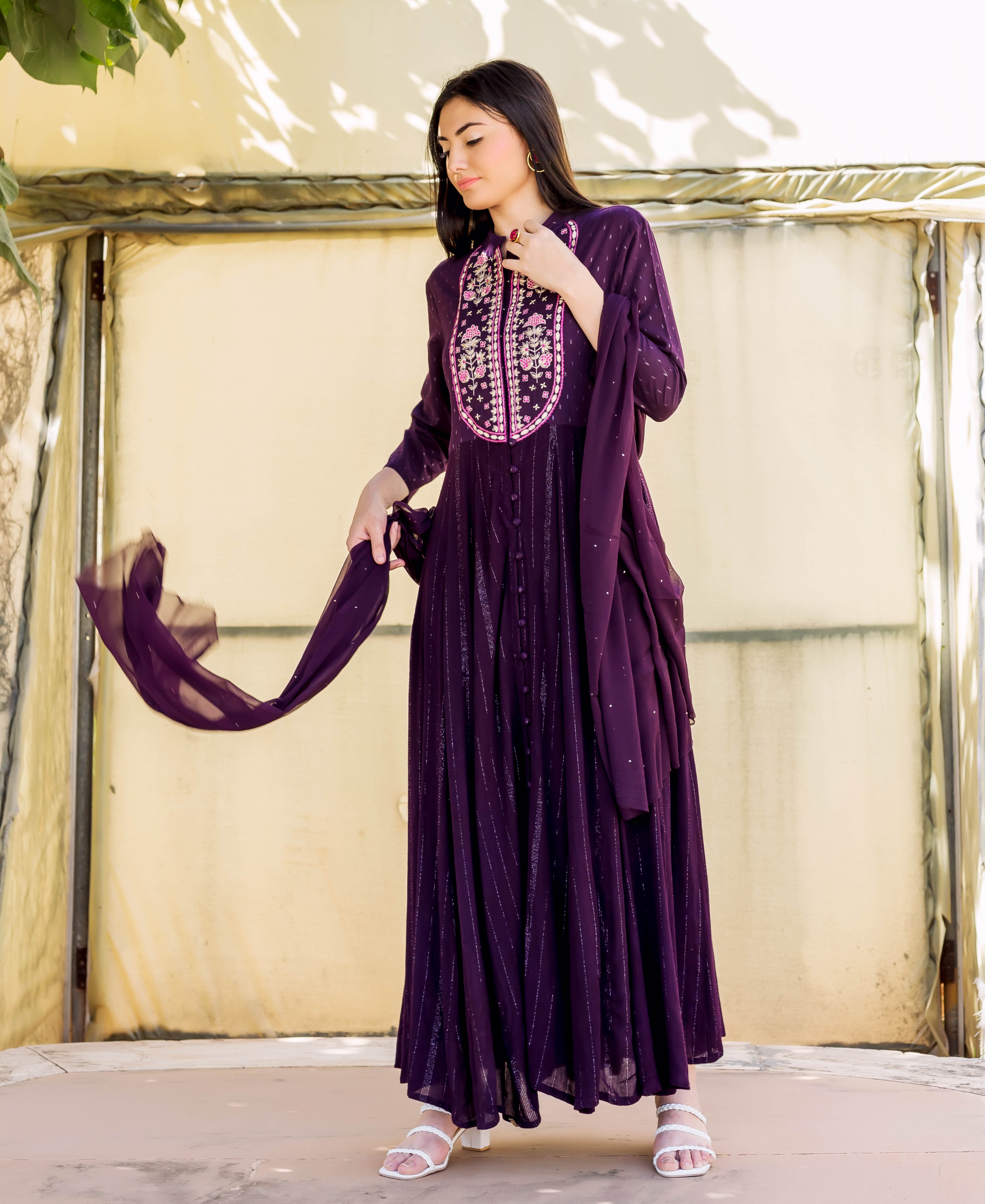 Full-length model in a wine lurex Anarkali dress with detailed floral embroidered yoke.