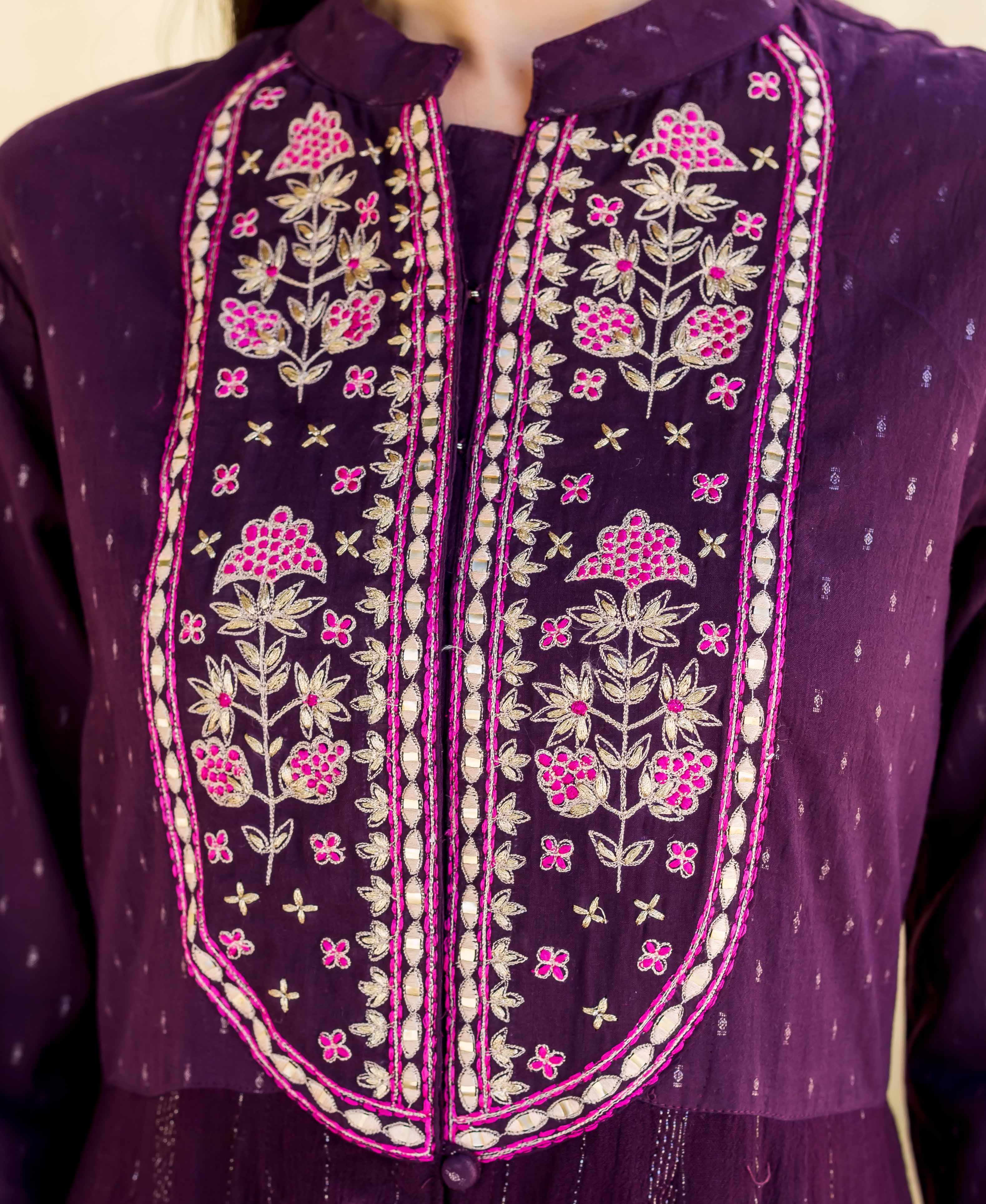 Close-up: Model in wine block-printed dress with pink, gold, and mirror embroidery.