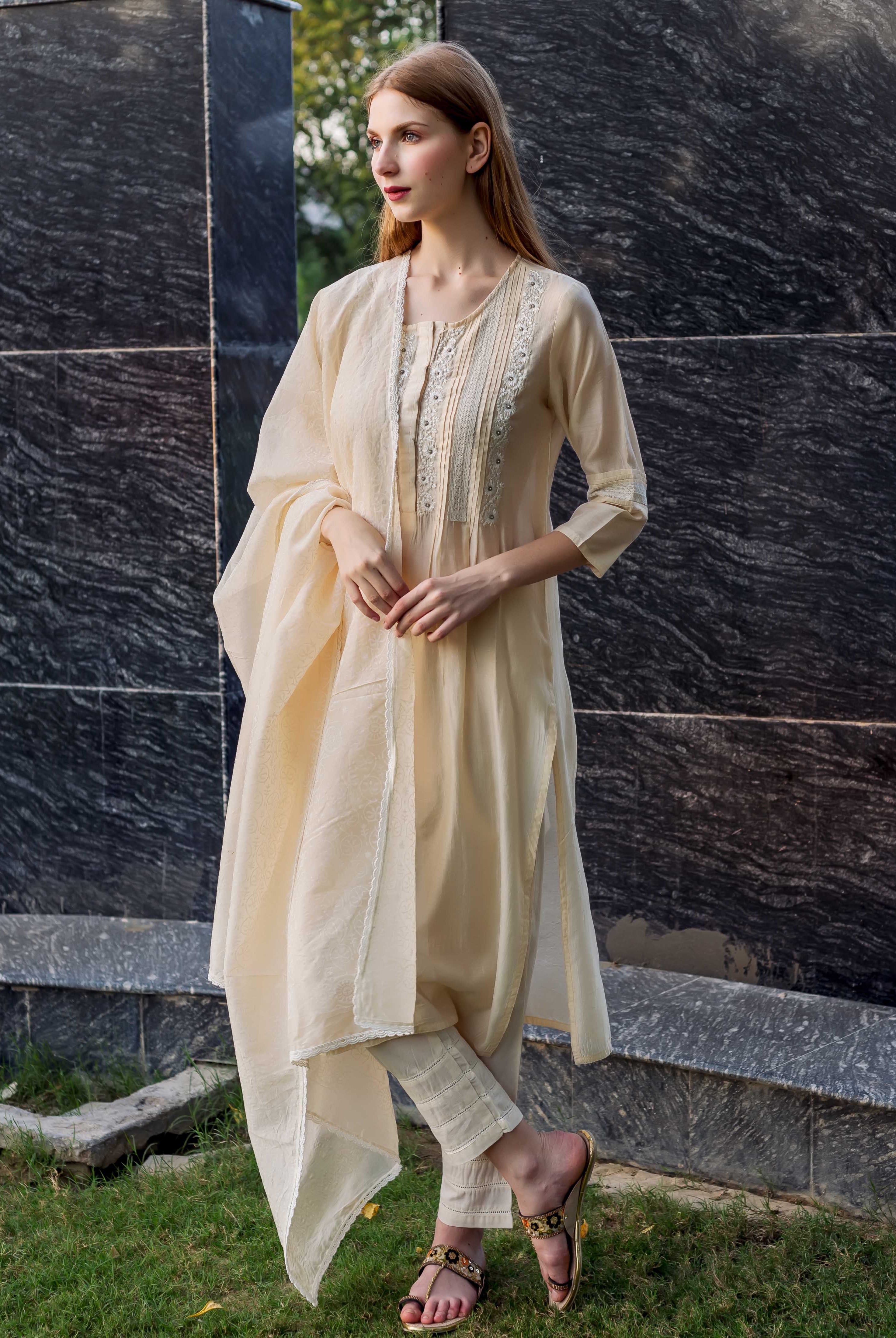 Model wears off-white embroidered kurta with pintuck and lace details, plus dupatta.
