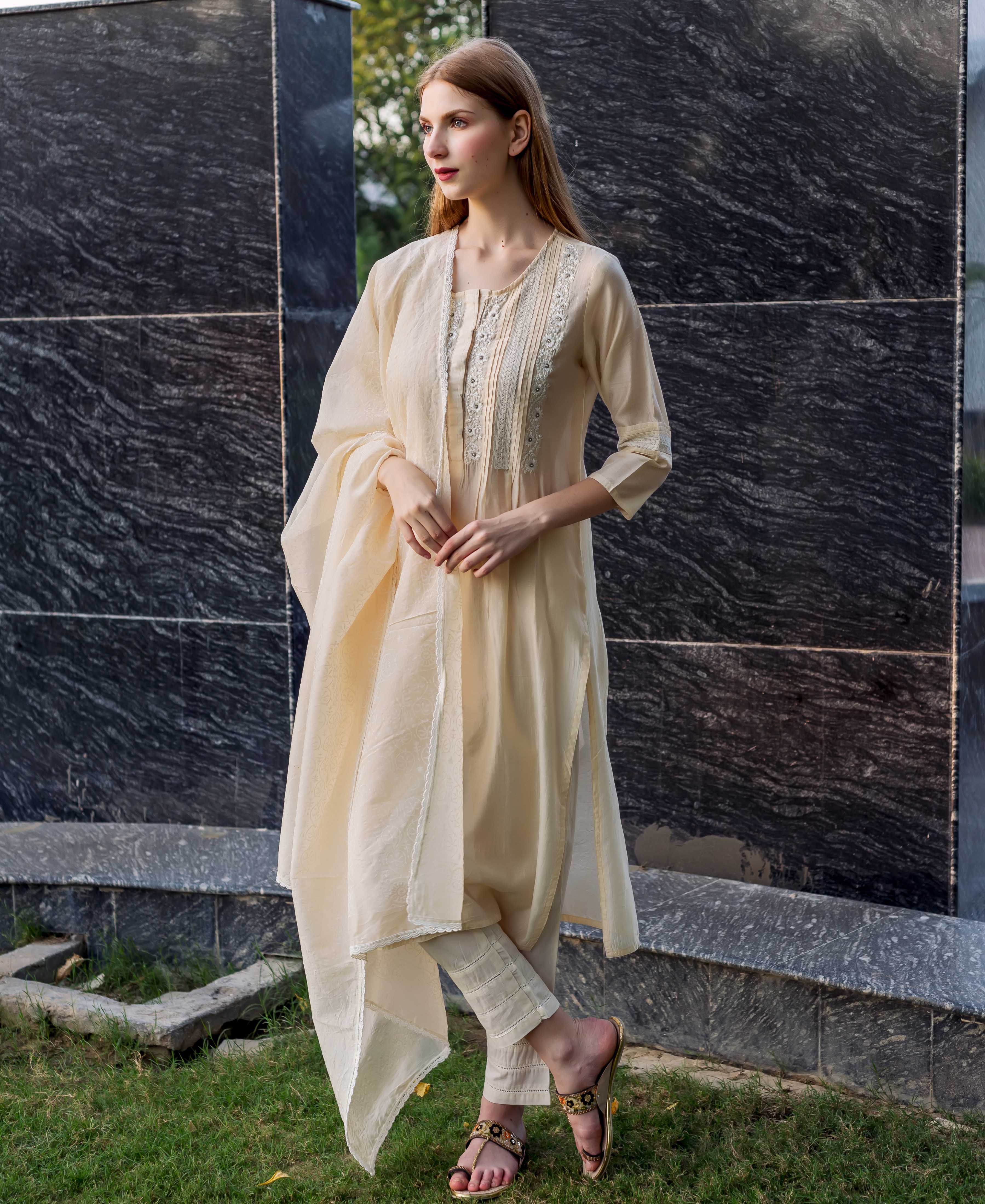 Model wears off-white embroidered kurta with pintuck and lace details, plus dupatta.