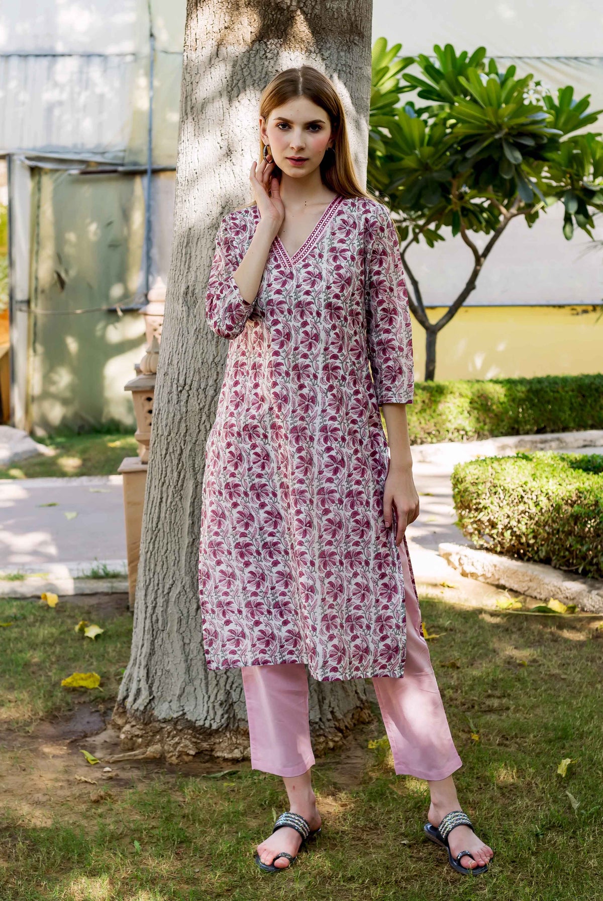 Full-length model in a pink hand-block printed floral kurta and light pink cropped pants.