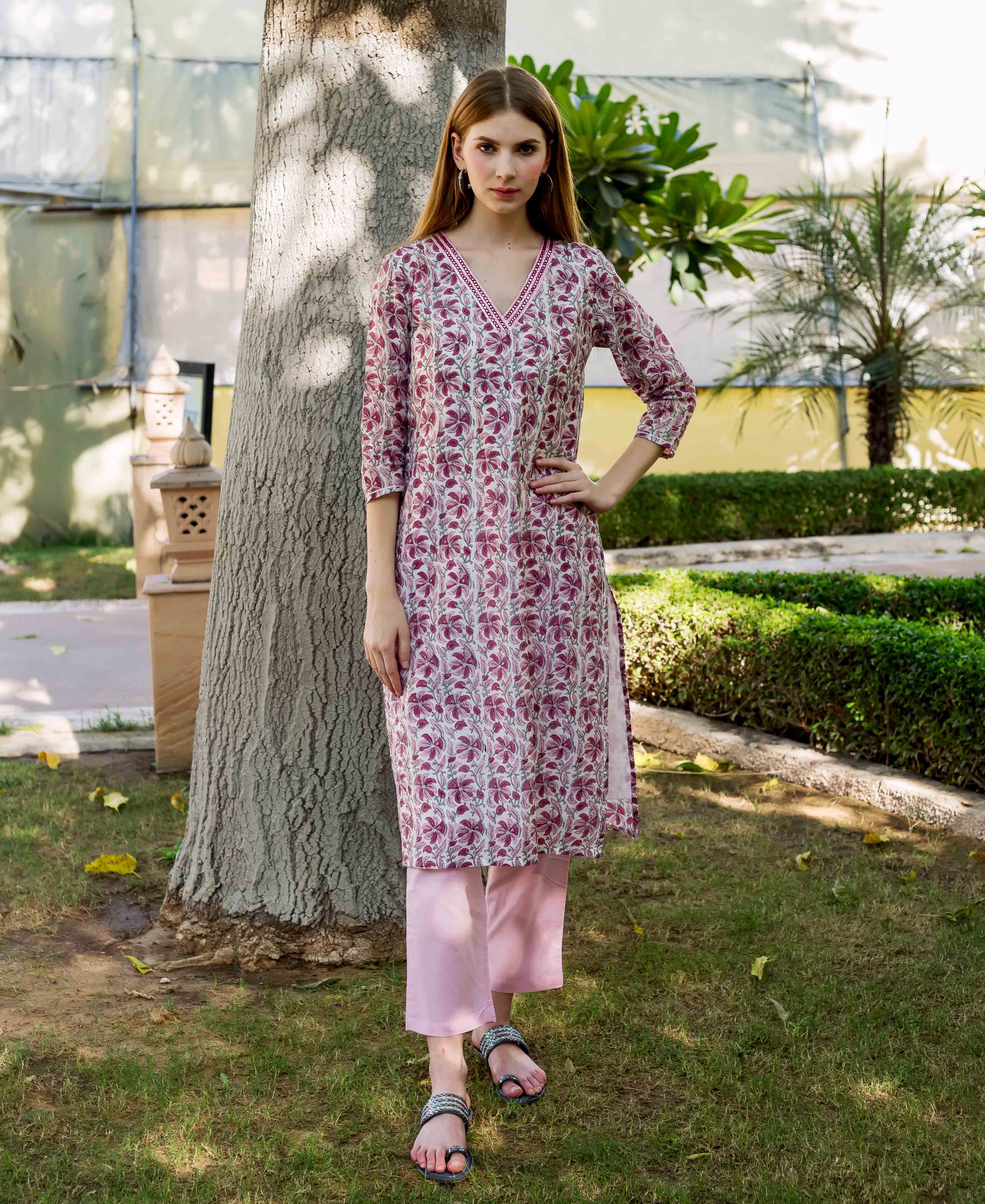 Full-length model wearing a pink and white floral hand-block printed kurta and pants.