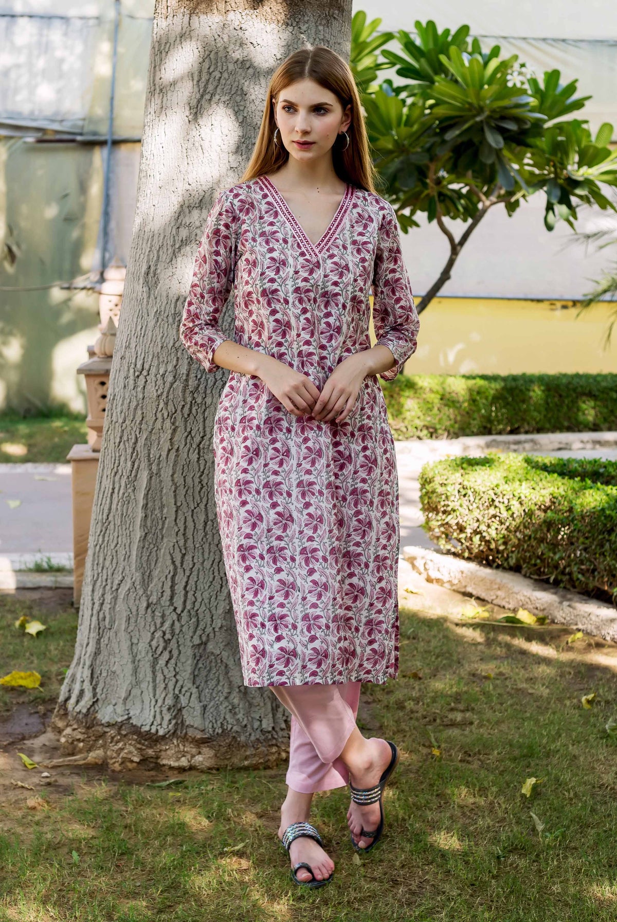 Full-length model wearing a pink and white hand-block printed floral V-neck kurta.