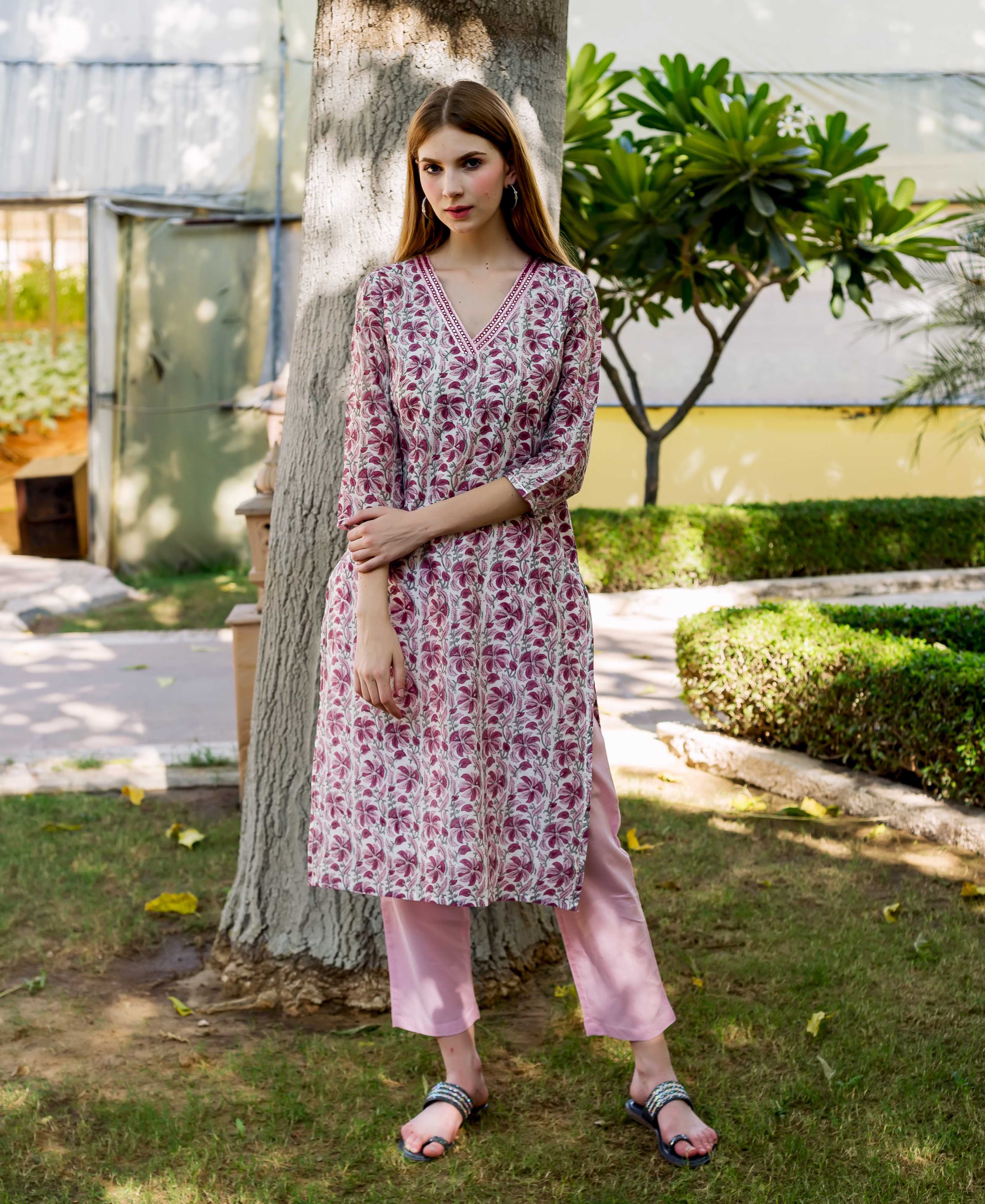 Full-length model in a white and maroon floral block-printed V-neck kurta and pink pants.