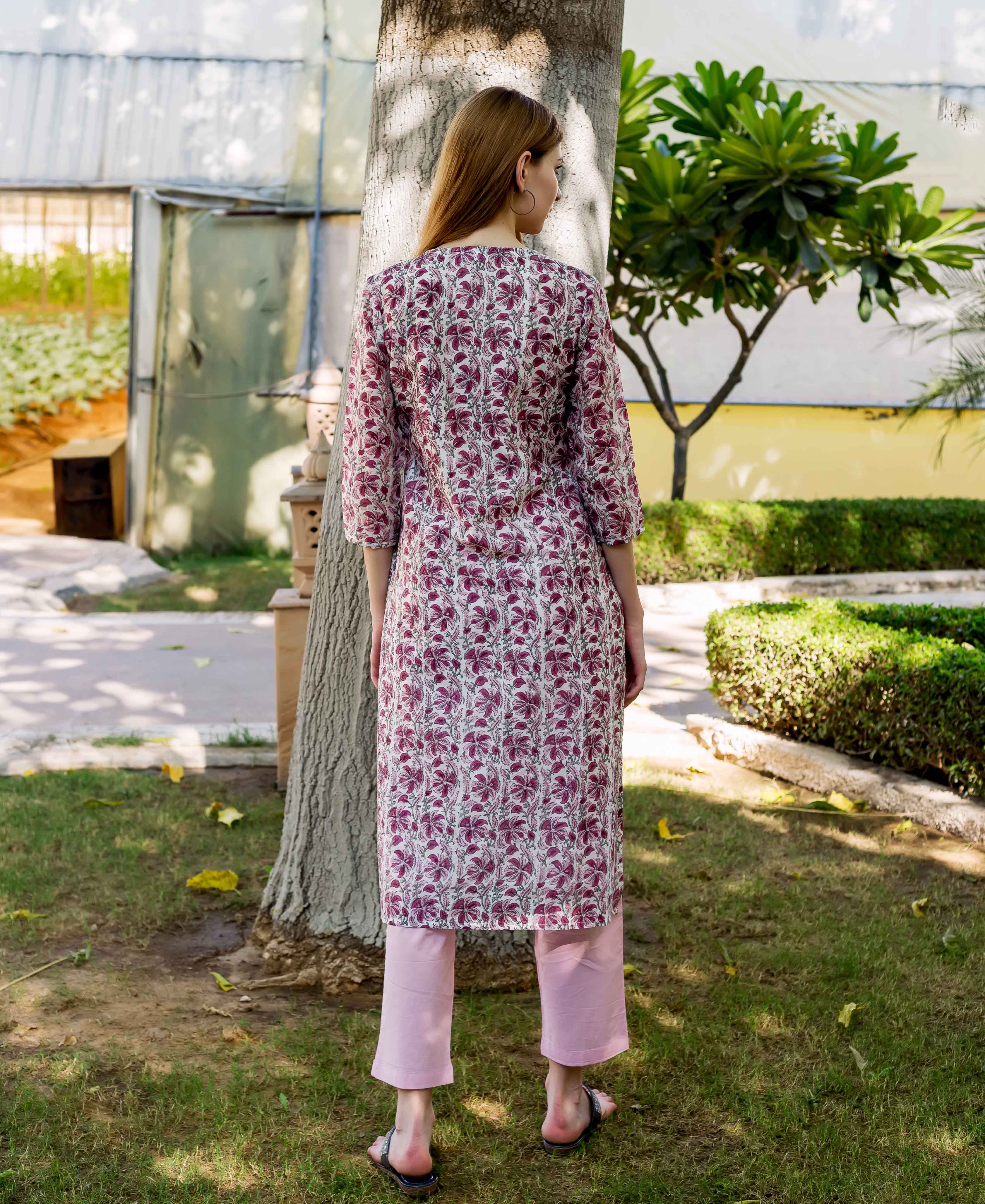 Back view of model in a hand-block-printed pink floral kurta and light pink pants.