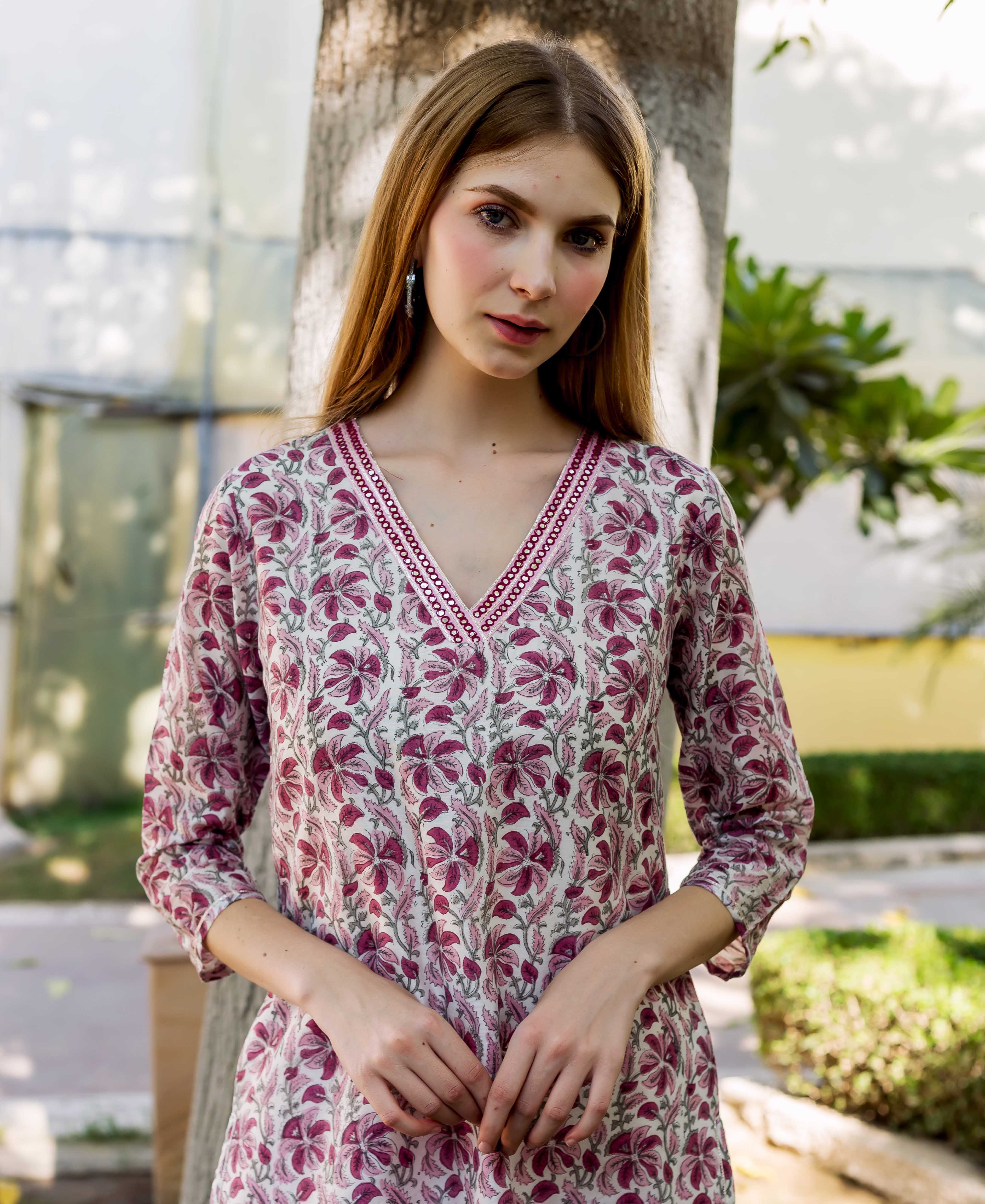 Model in a cream V-neck kurta with deep pink hand-block printed floral design.