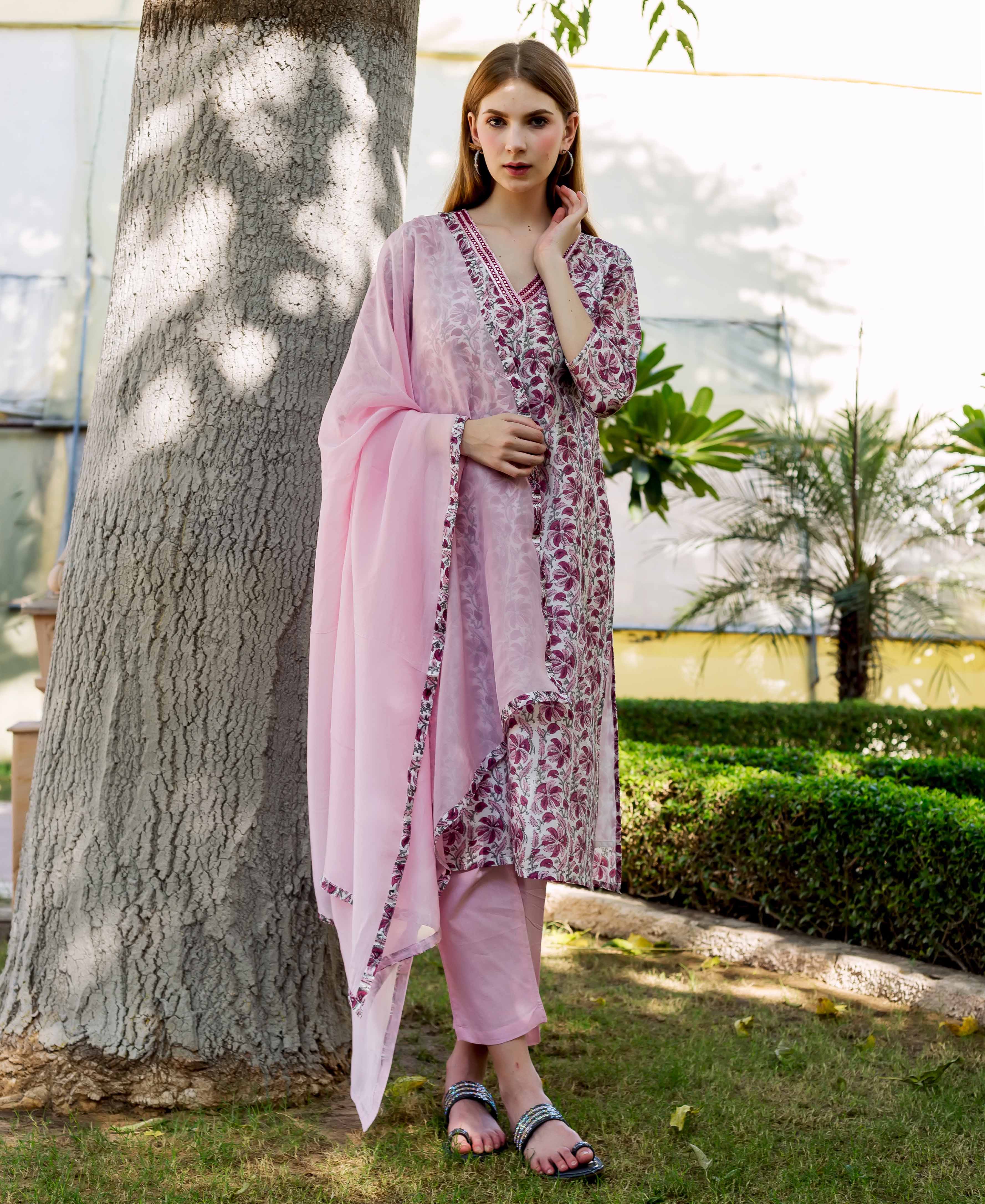 Full shot of a model wearing a pink hand-block-printed kurta set with maroon floral print.